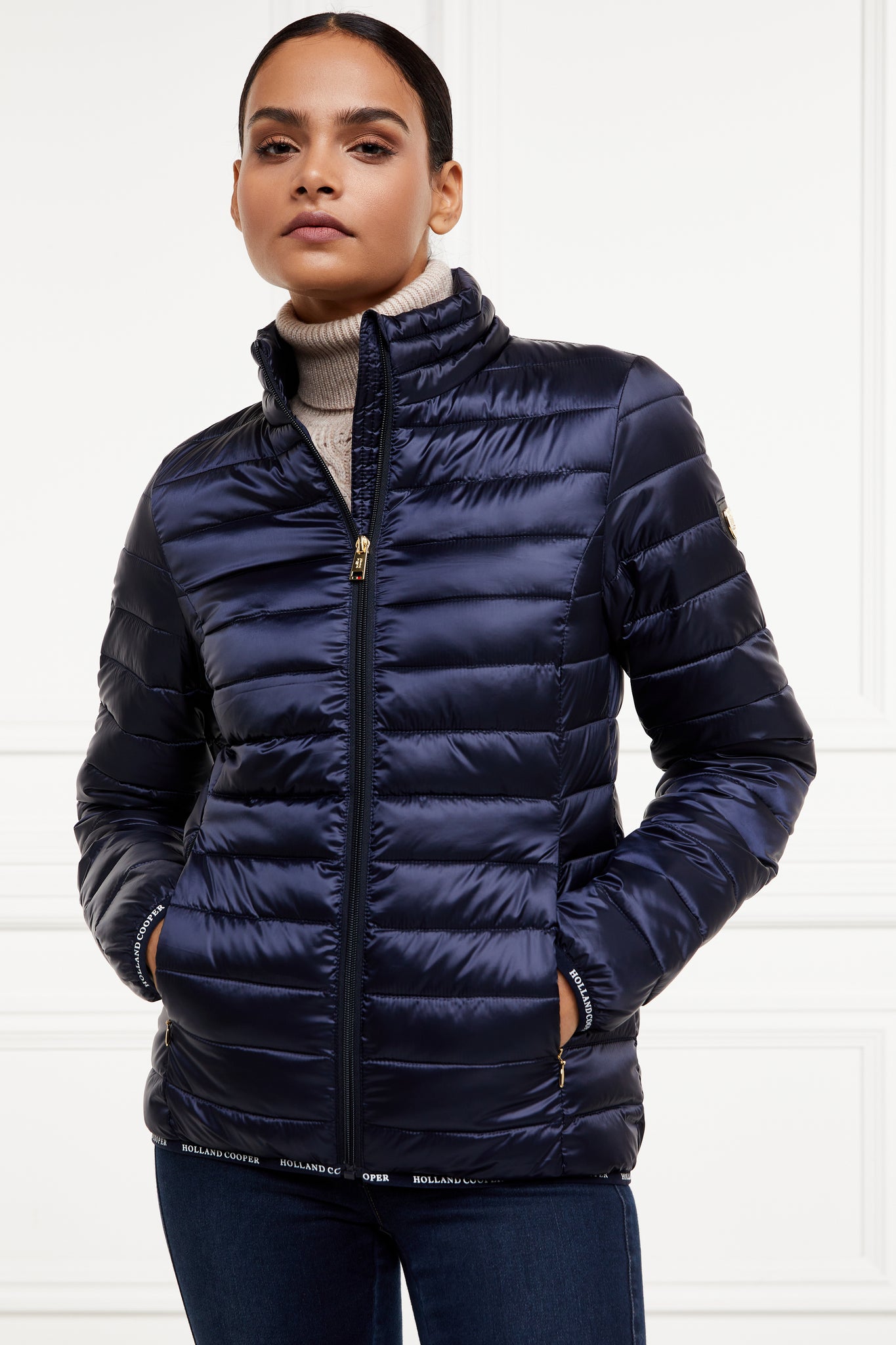 womens lightweight hoodless padded navy jacket with embroidery detail on back high neck and elasticated cuffs and hem. easily packs away into seperate small bag of the same colour with handle 