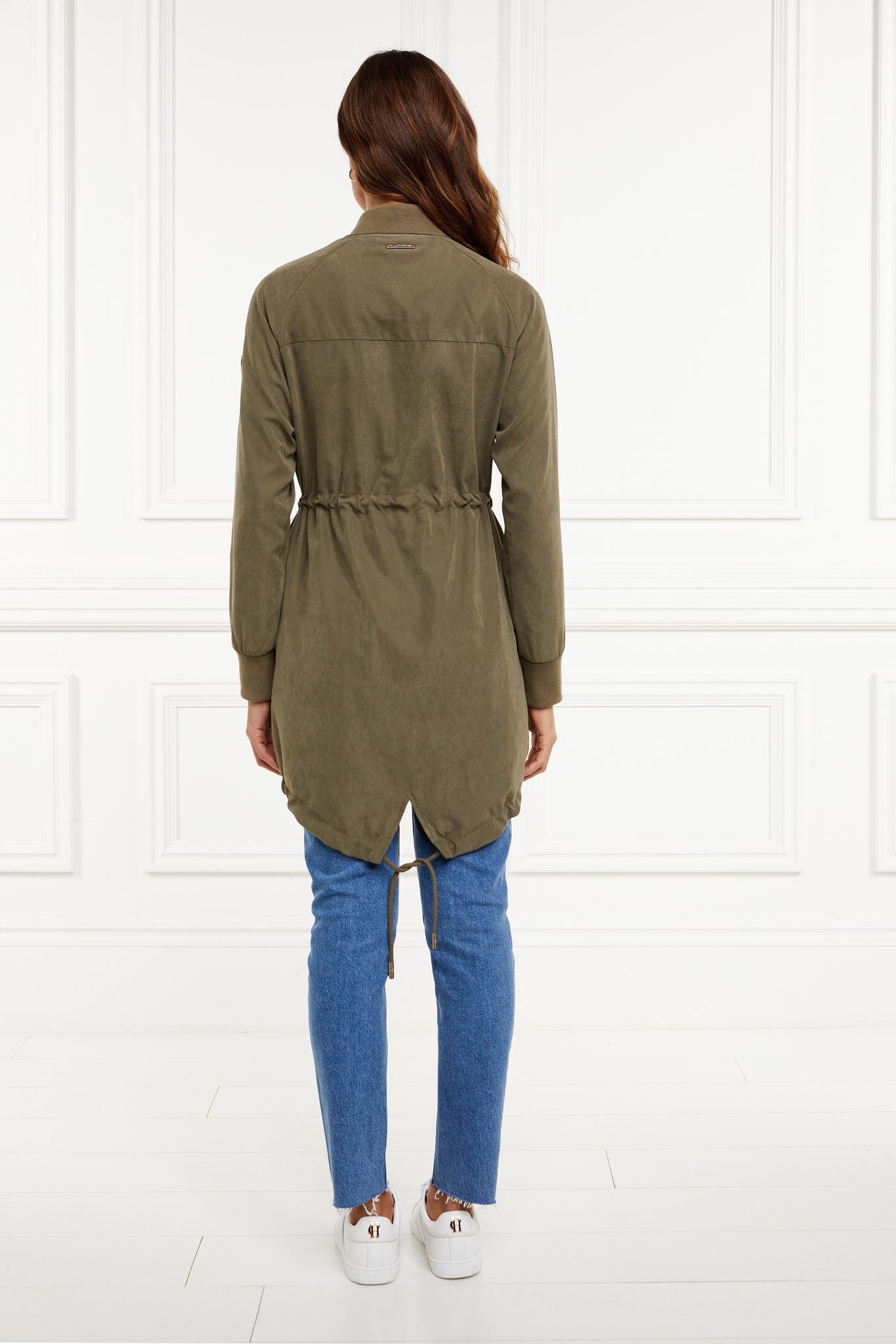 back of brushed suede longline lightweight parka jacket in khaki with an adjustable drawstring waist and fishtail hem and ribbed baseball style jersey collar and cuffs finished with gold hardware and gold shield on sleeve