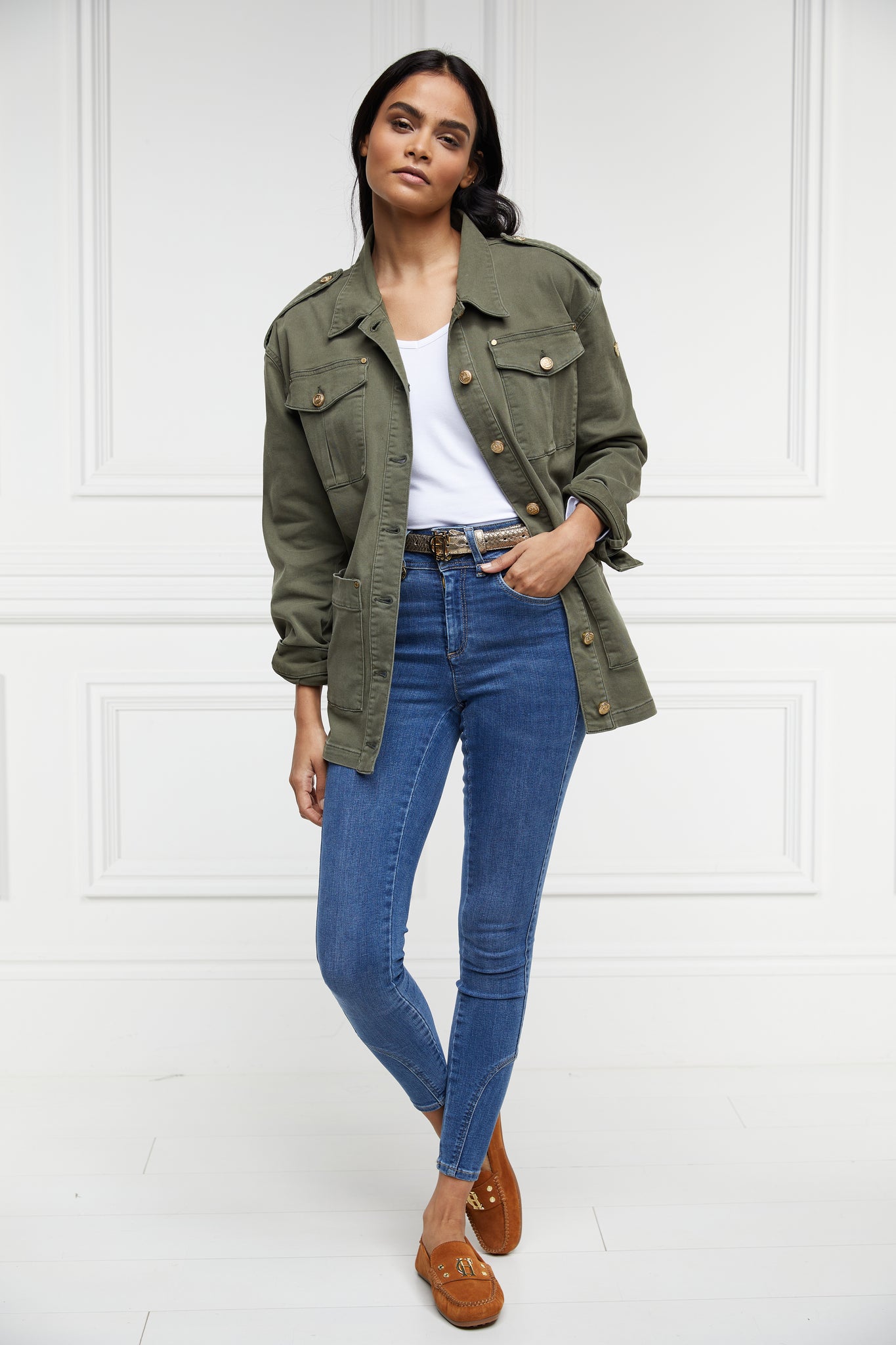 Relaxed fit collared artillery style jacket in khaki with four pockets two chest ones being box pleated  and two hip being patch pockets with gold jean button fastenings adjustable long sleeves and epaulette shoulder detail worn with white tee classic indigo denim jeans and tan suede loafers