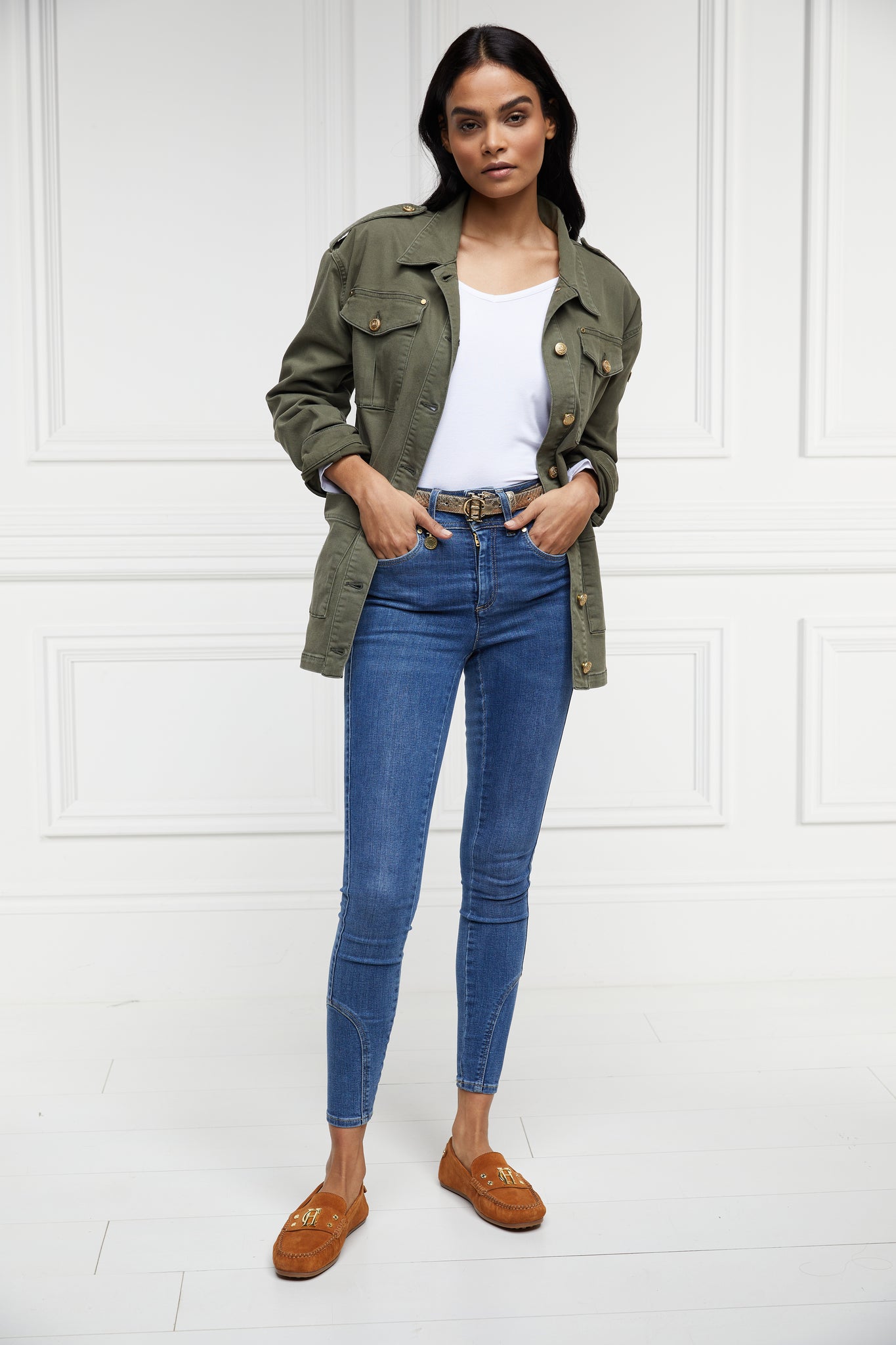 Relaxed fit collared artillery style jacket in khaki with four pockets two chest ones being box pleated  and two hip being patch pockets with gold jean button fastenings adjustable long sleeves and epaulette shoulder detail worn with white tee classic indigo skinny jeans and tan suede loafers 