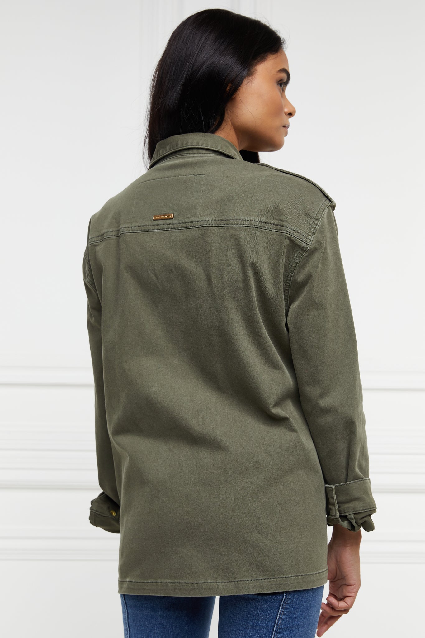 back of Relaxed fit collared artillery style jacket in khaki with four pockets two chest ones being box pleated  and two hip being patch pockets with gold jean button fastenings adjustable long sleeves and epaulette shoulder detail