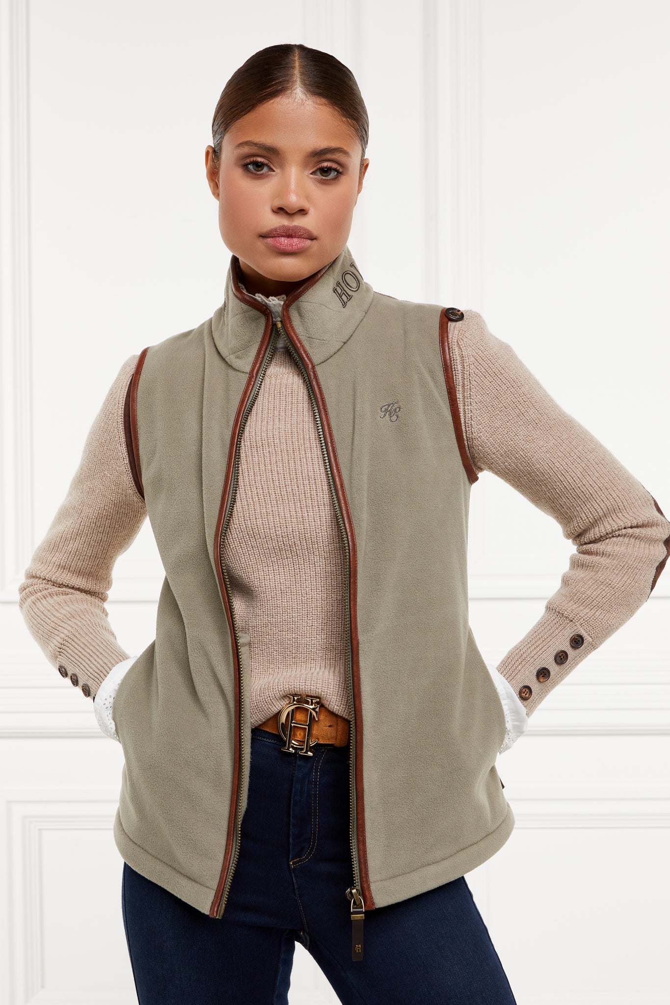 womens fleece gilet in sage green with dark brown leather piping around armholes neckline and down the front zip fastening