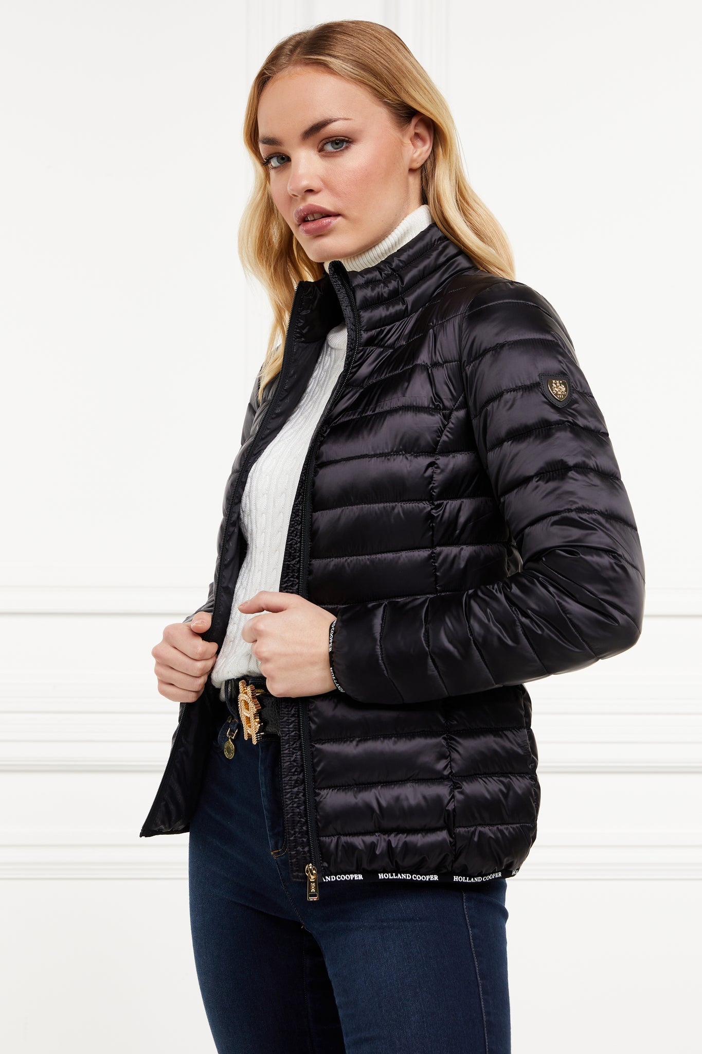 womens lightweight hoodless padded black jacket with embroidery detail on back high neck and elasticated cuffs and hem. easily packs away into separate small bag of the same colour with handle 
