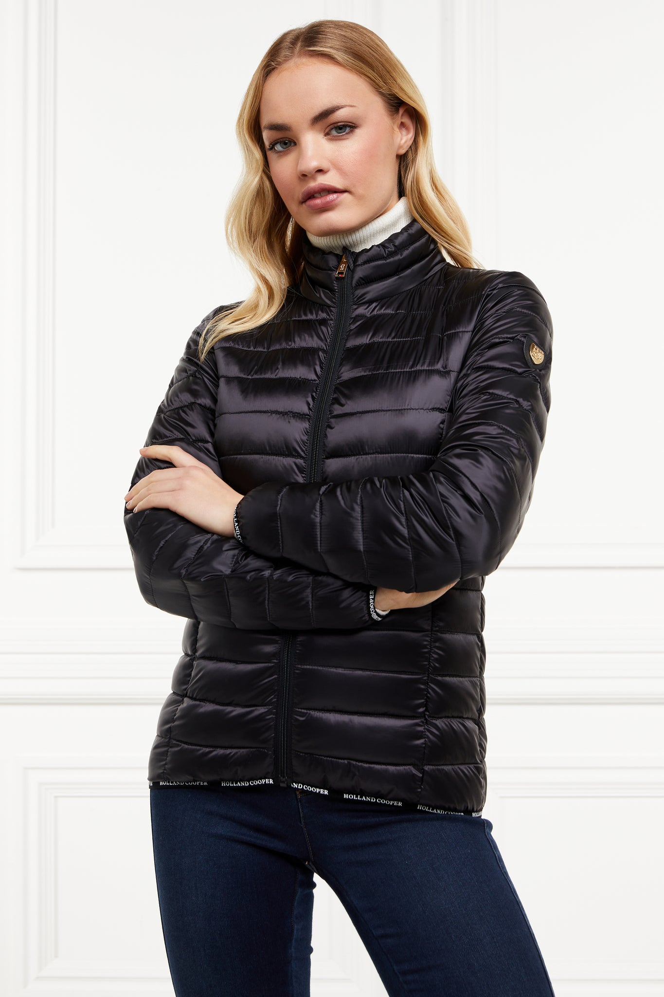 womens lightweight hoodless padded black jacket with embroidery detail on back high neck and elasticated cuffs and hem. easily packs away into separate small bag of the same colour with handle  