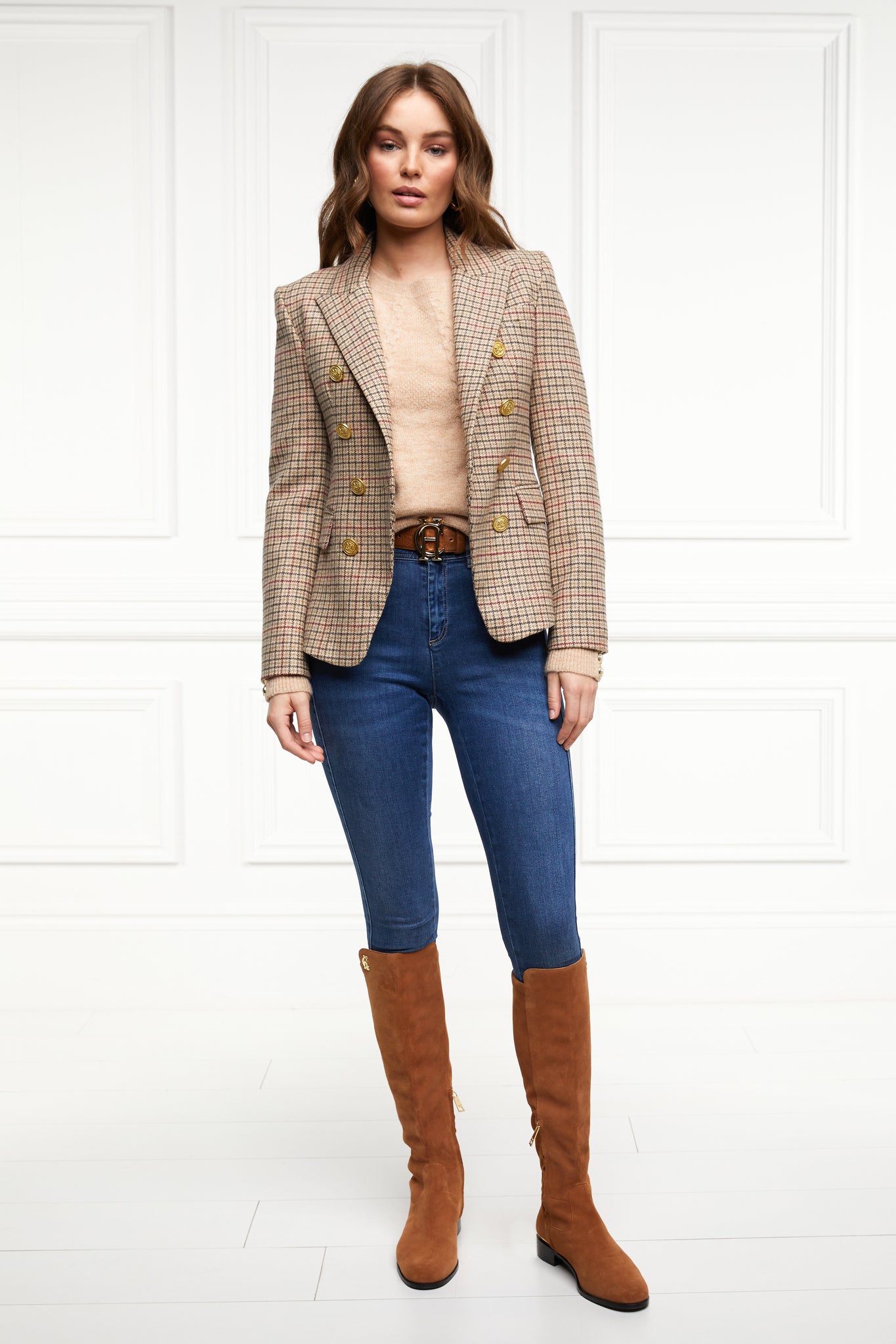British made double breasted blazer that fastens with a single button hole to create a more form fitting silhouette with two pockets and gold button detailing this blazer is made from camel black and red check charlton tweed worn with camel jumper classic indigo skinny jeans and tan knee high boots