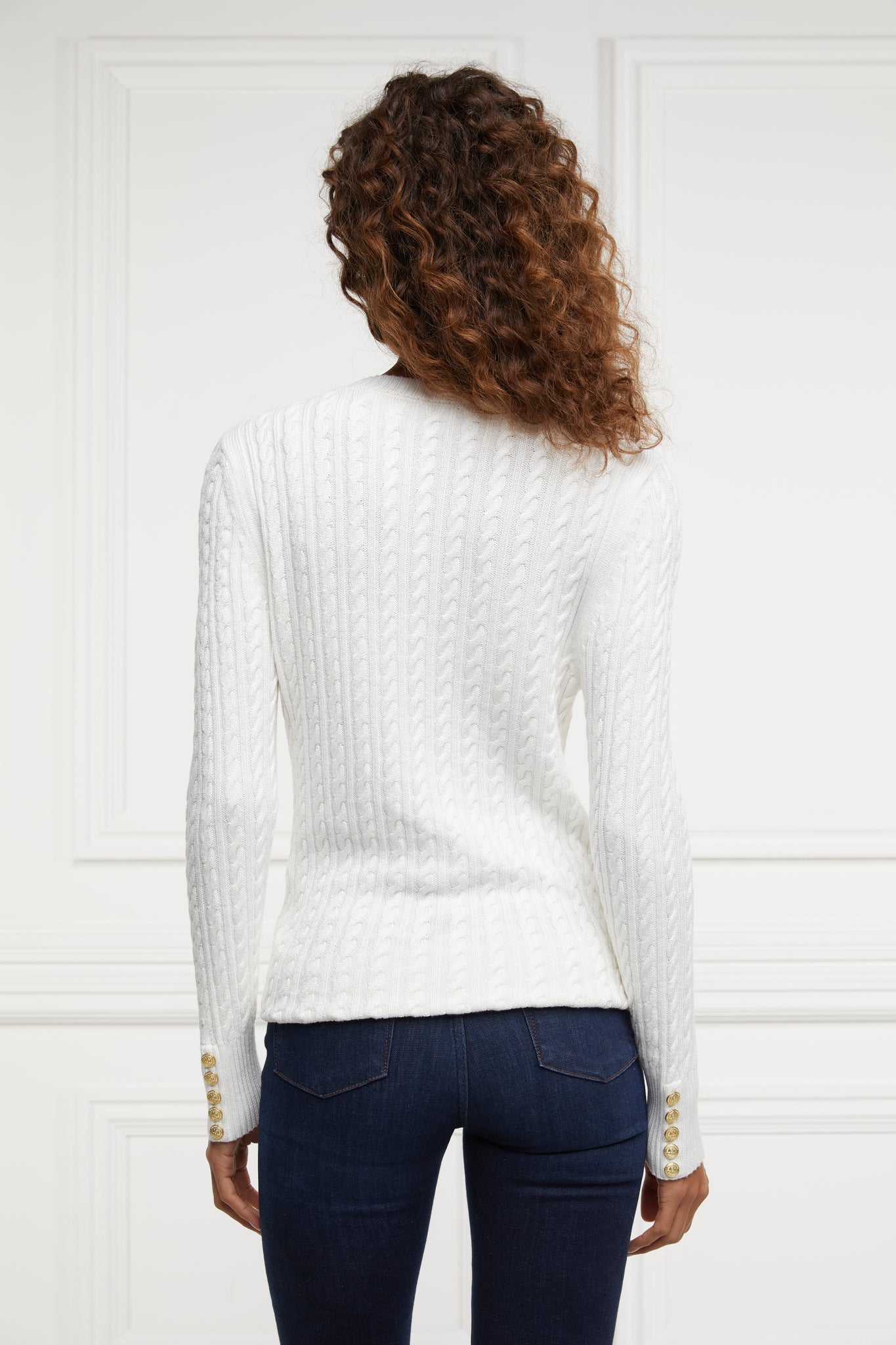 back of womens lightweight v neck cable knit jumper in white detailed with gold buttons at the cuffs