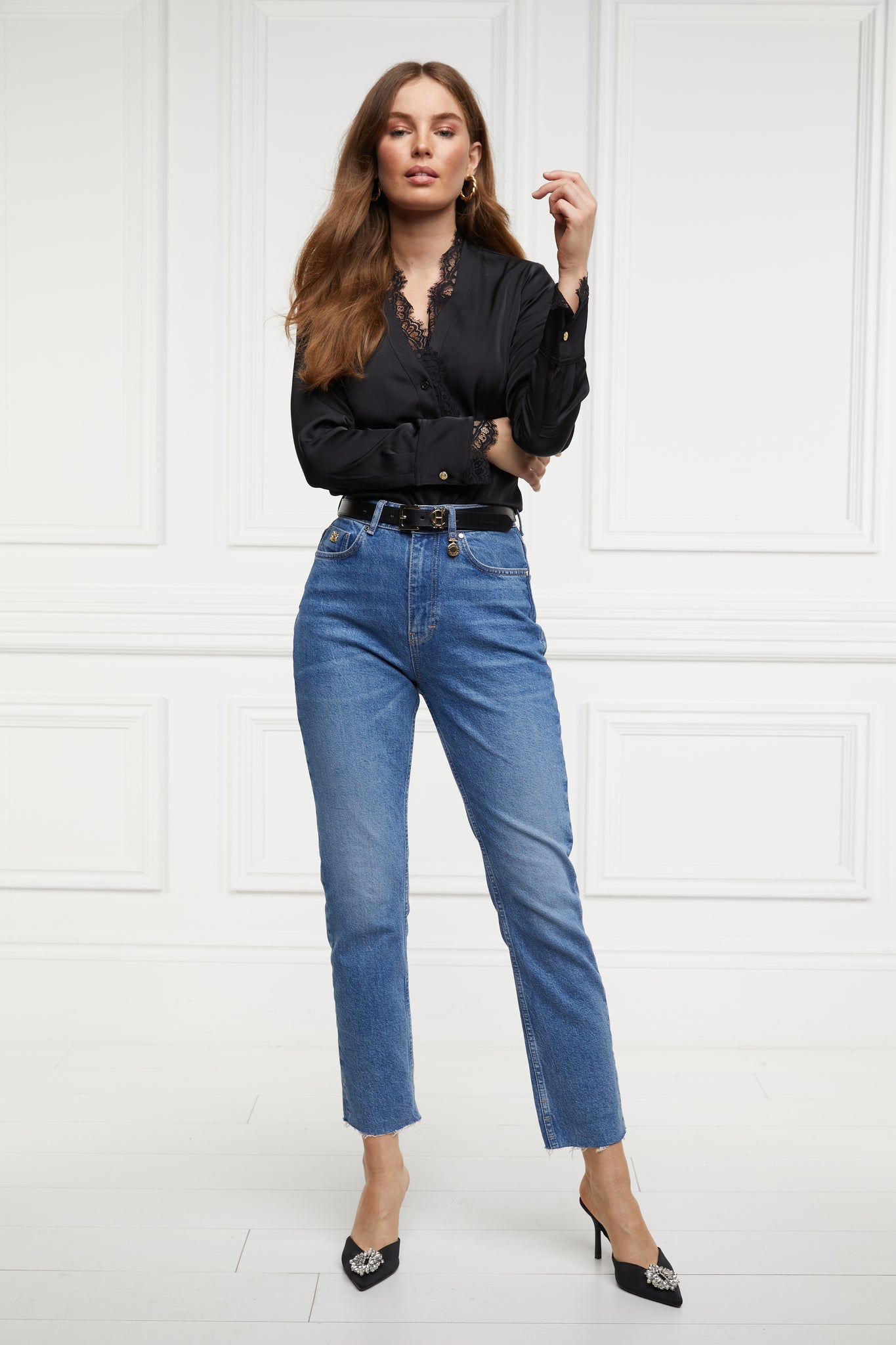 womens high rise blue denim slim fit jean with raw hem and two open pockets on the front and back with gold stirrup charm to the belt loop