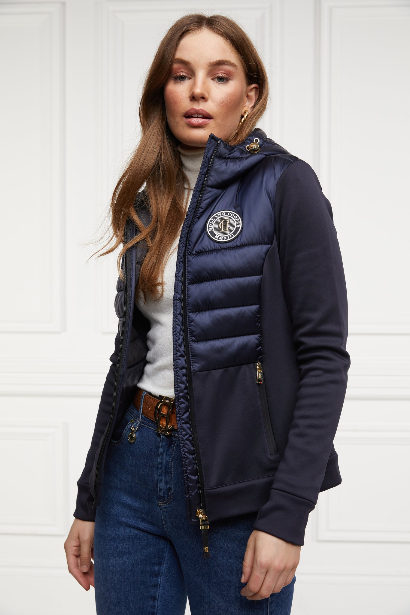 hooded hybrid jacket in navy with jersey panels on the waist and sleeves and Sorona eco down fill on hood front and back body panels finished with rubbed zip fastening in black and two side pockets with the same zip fastenings