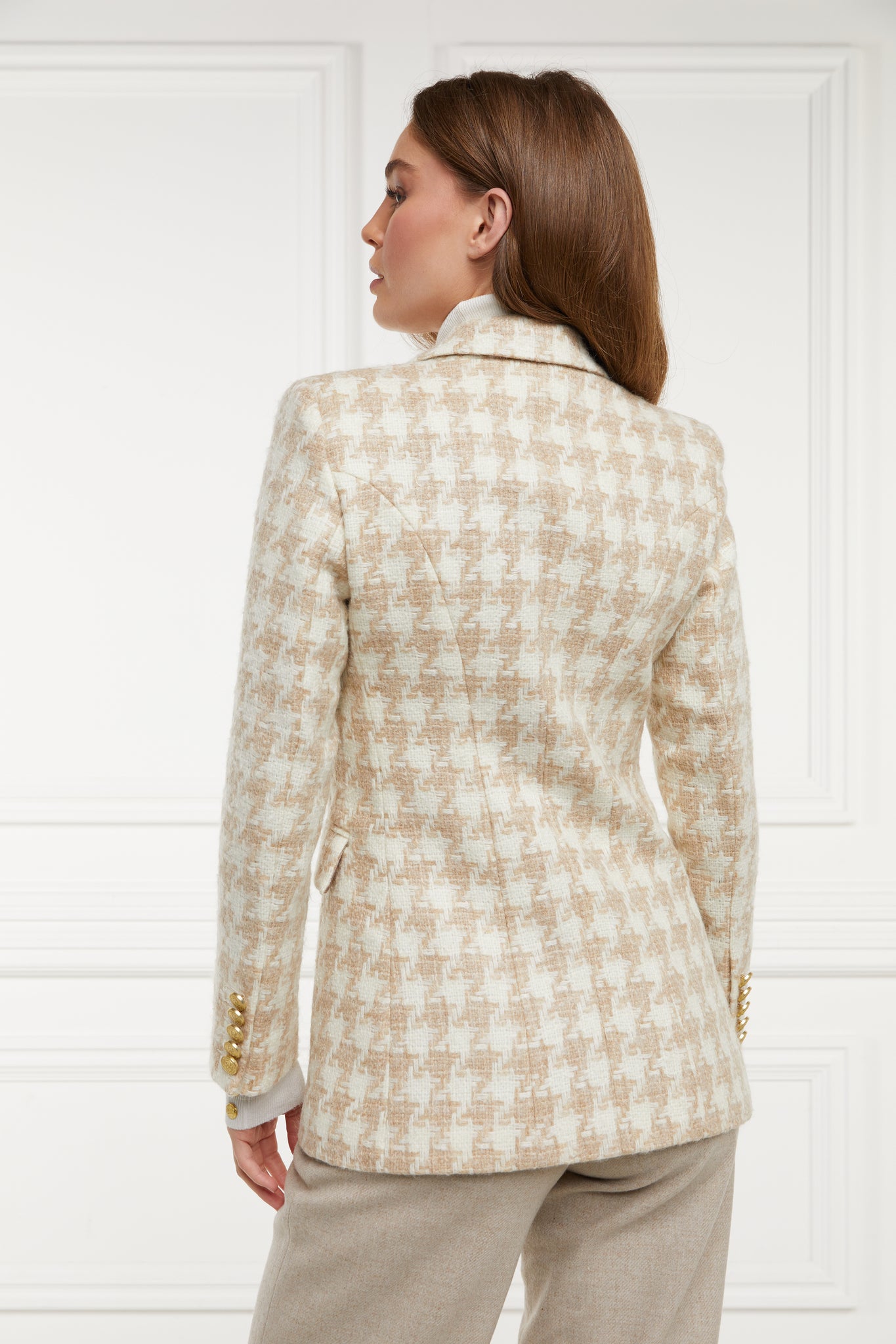 back of double breasted wool blazer in white and camel houndstooth with two hip pockets and gold button details down front and on cuffs and handmade in the uk