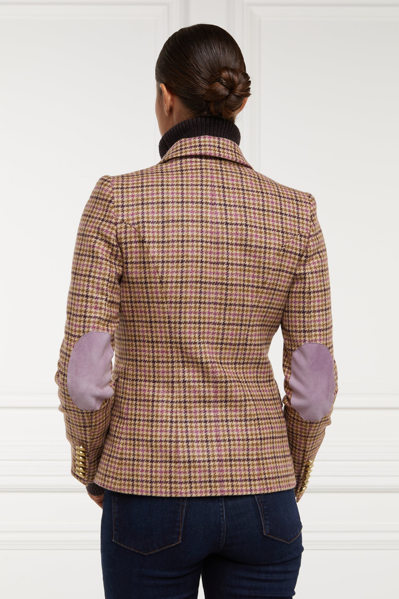 back of British made double breasted blazer that fastens with a single button hole to create a more form fitting silhouette with two pockets and gold button detailing this blazer is made from pink purple and brown check houndstooth fabric highlighting pale pink suede elbow patches