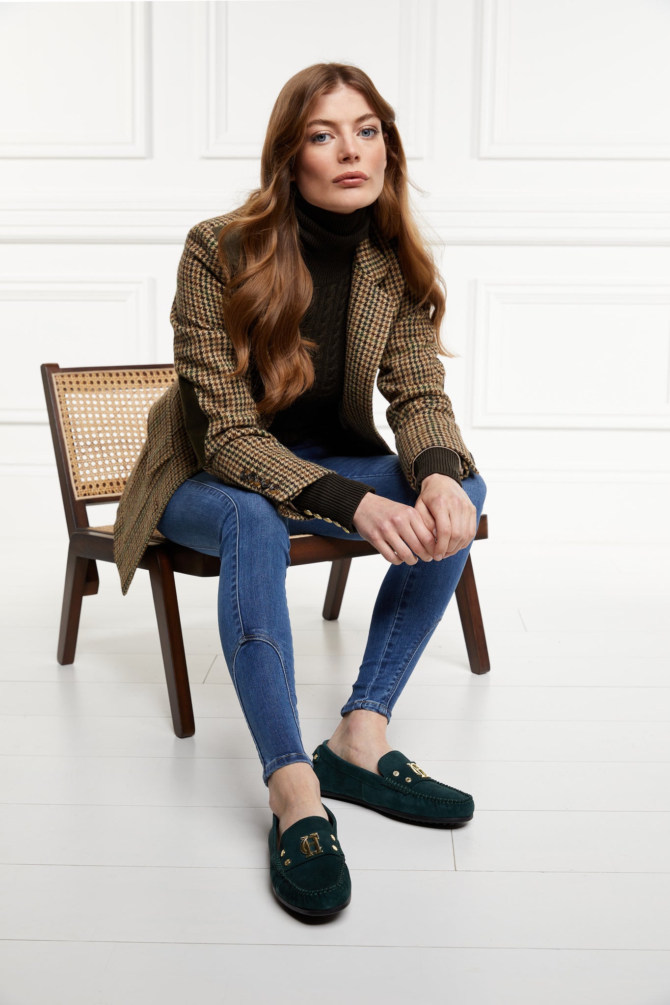 classic emerald green suede loafers with a leather sole and top stitching details and gold hardware paired with a classic denim skinny jean, dark green cable knit roll neck jumper and a green checked blazer