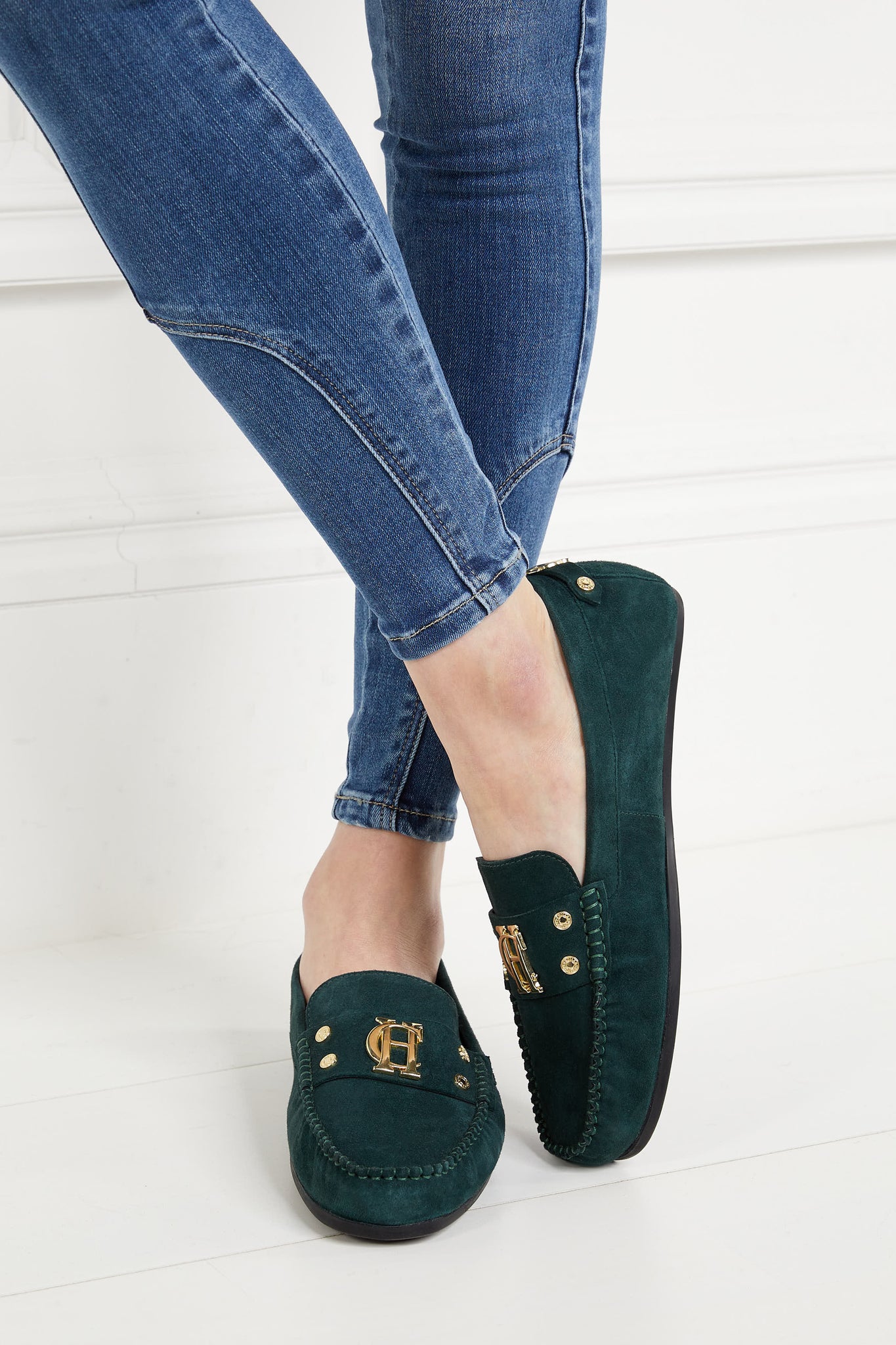 classic emerald green suede loafers with a leather sole and top stitching details and gold hardware paired with a classic denim skinny jean