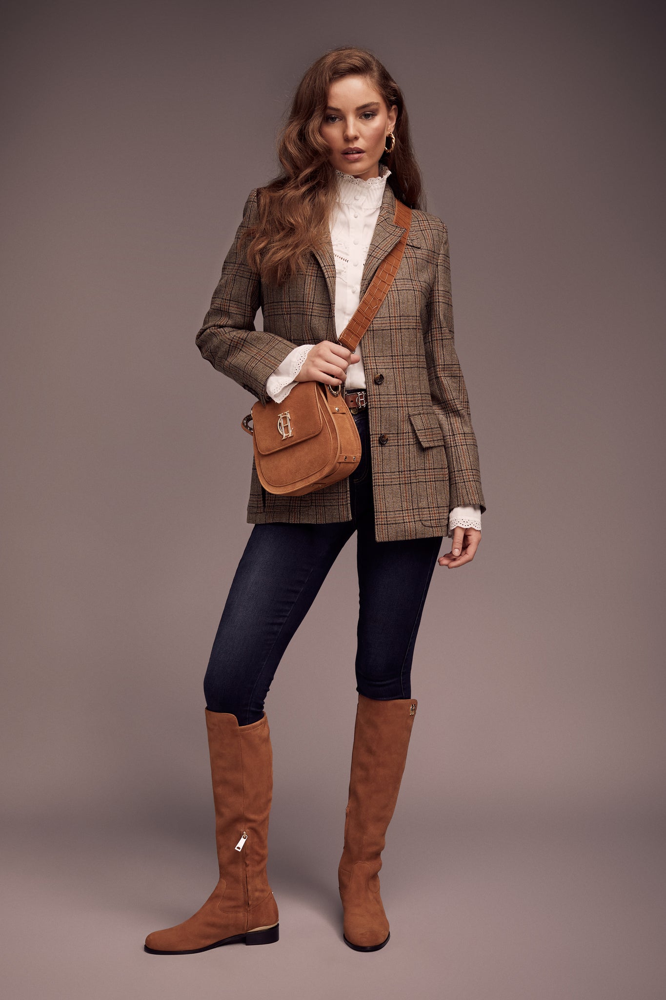 womens classic slim fit single breasted blazer in brown and orange tweed with lower patch pockets with concealed button flap contrast brown suede shoulder gun patch with elbow patches and horn button finish on cuffs and front worn with navy skinny jeans tan knee high boots and white shirt