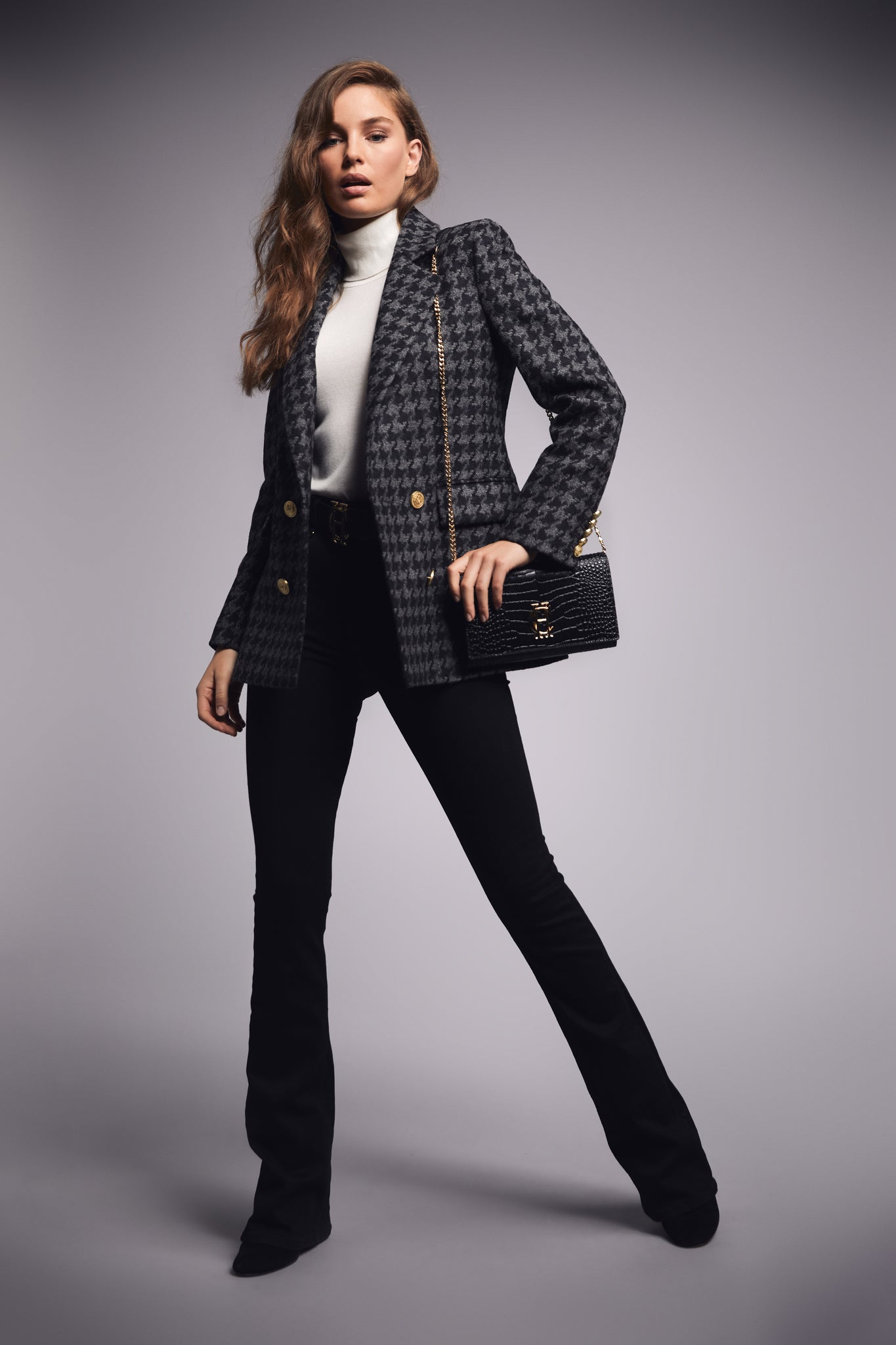 womens grey houndstooth tweed blazer with black flared jeans and black croc embossed leather clutch bag with gold hardware and gold chain 