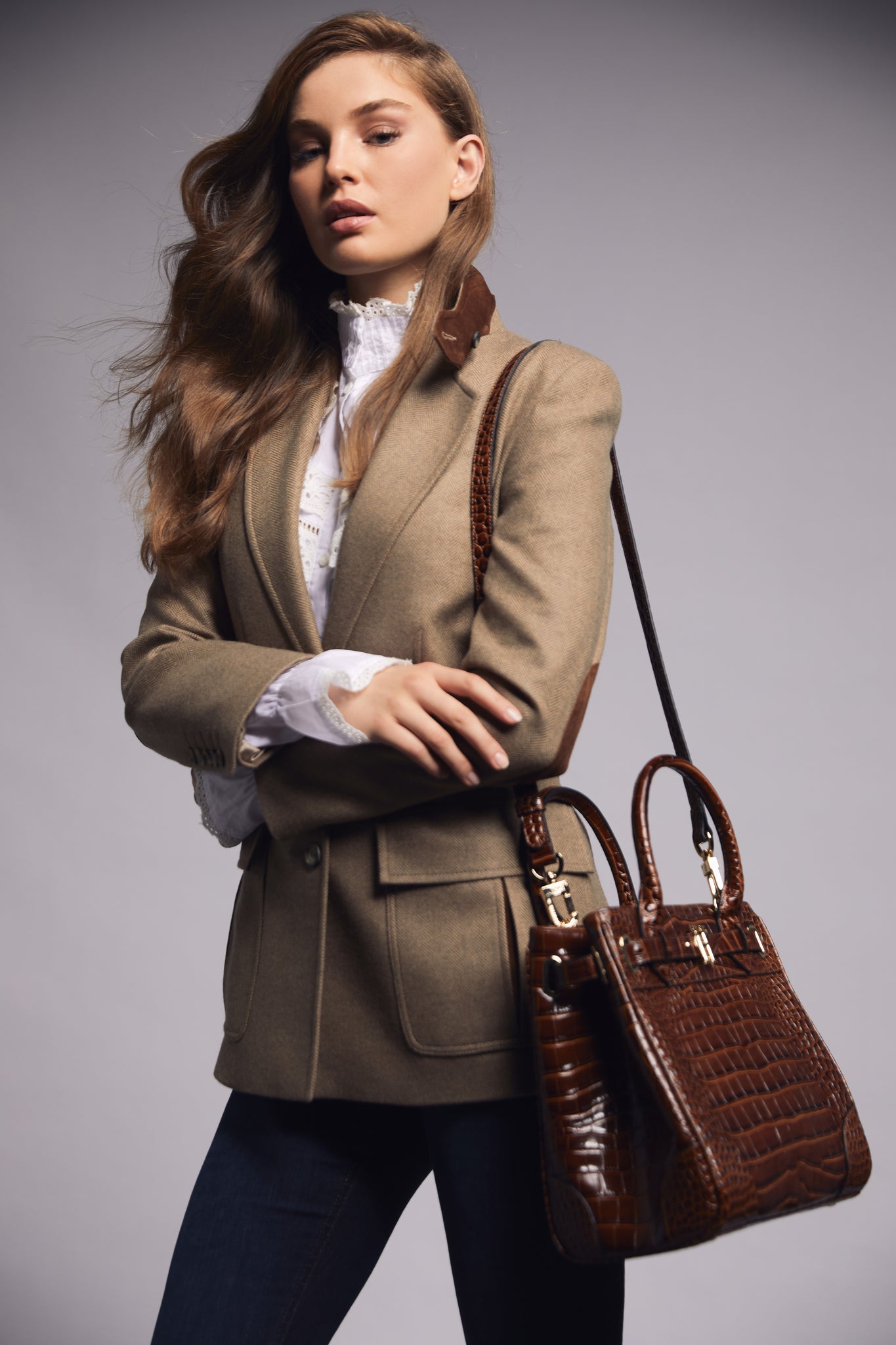 womens tailored fit single breasted blazer in camel herringbone with patch pockets and contrast tan suede elbow patches and underside collar worn with white shirt and tan tote bag