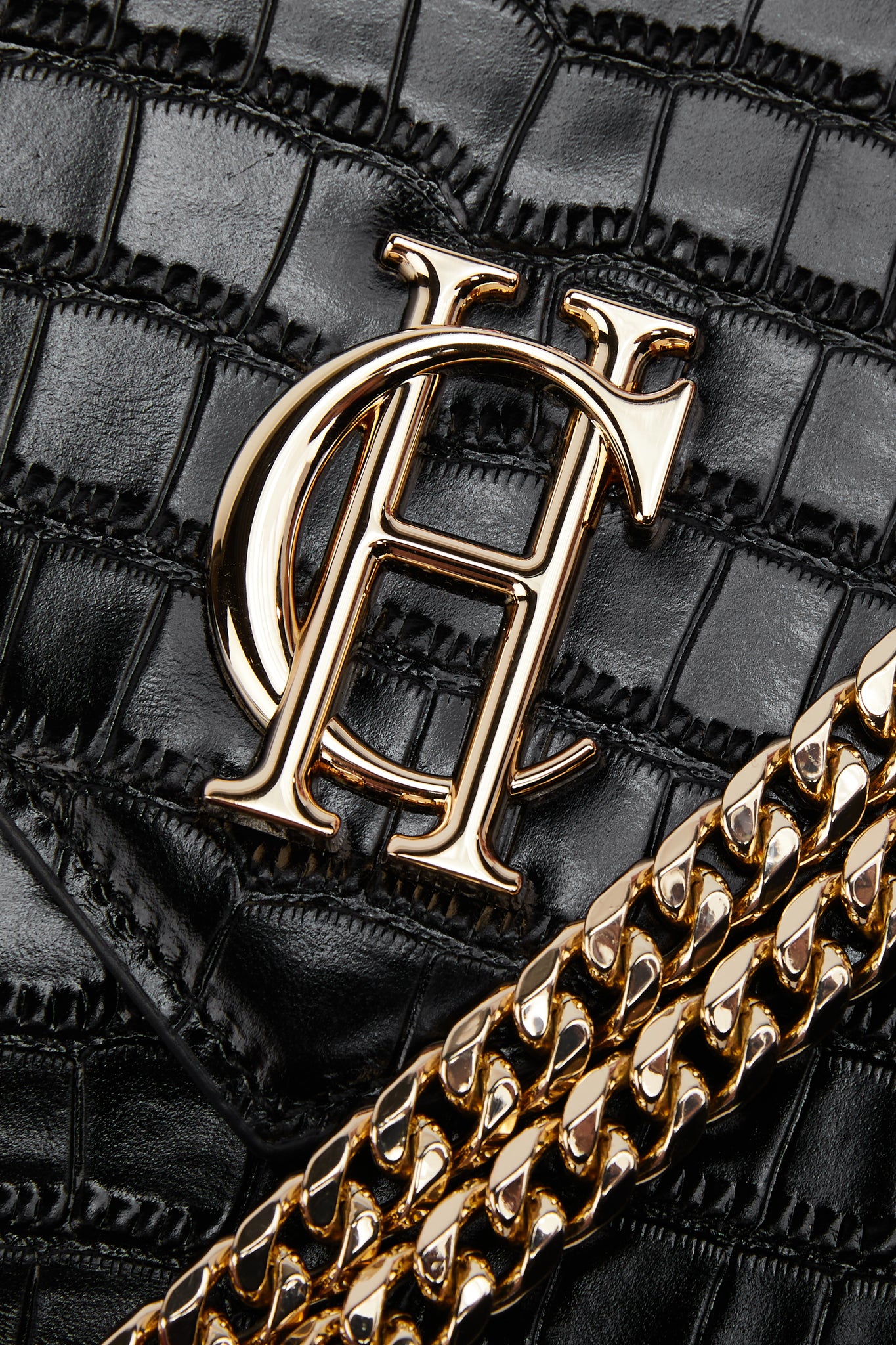 close up of gold hardware and gold chain on black croc embossed leather shoulder bag
