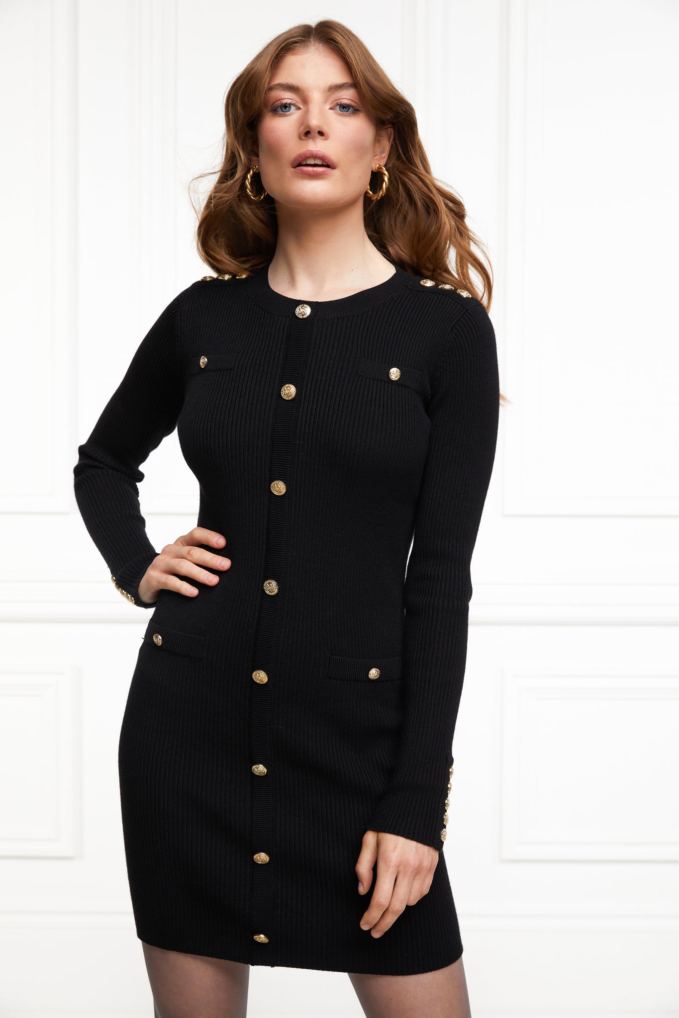 womens slim fit crew neck long sleeve knitted dress in black with gold button detail down the centre front and two welt pockets on chest and two on the hips with gold buttons on the centre of each pocket
