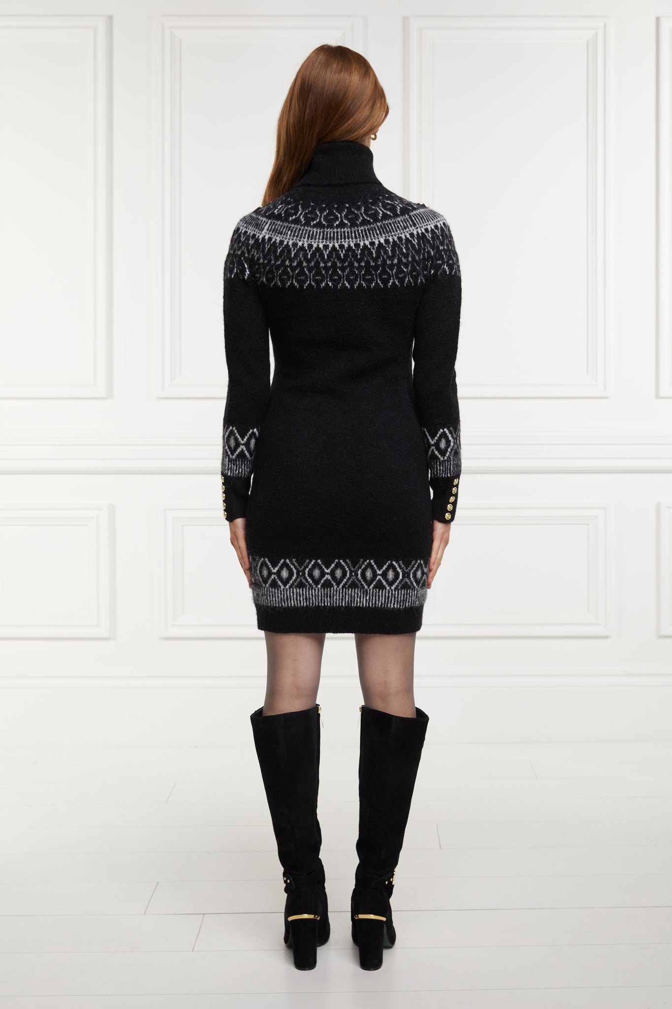back of womens black roll neck jumper dress with fairisle knit in white and grey around the shoulders hemline and cuffs and a ribbed hem with gold buttons on shoulders and cuffs