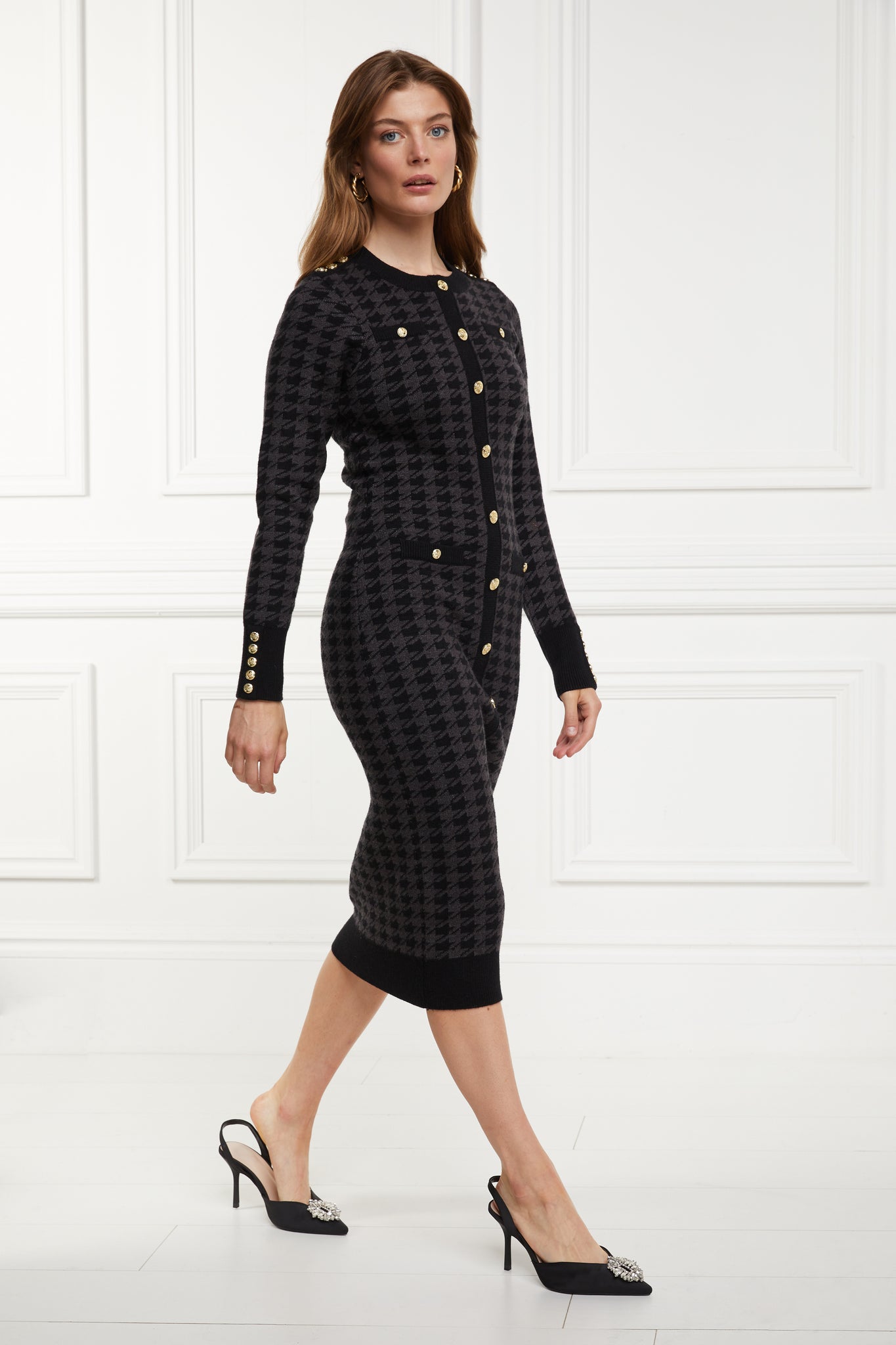side of womens slim fit crew neck long sleeve knitted midi dress in grey and black houndstooth with gold button detail on contrast black panel down the centre front and two black contrast welt pockets on chest and two on the hips with gold buttons on the centre of each and contrasting black ribbed hem neckline and cuffs