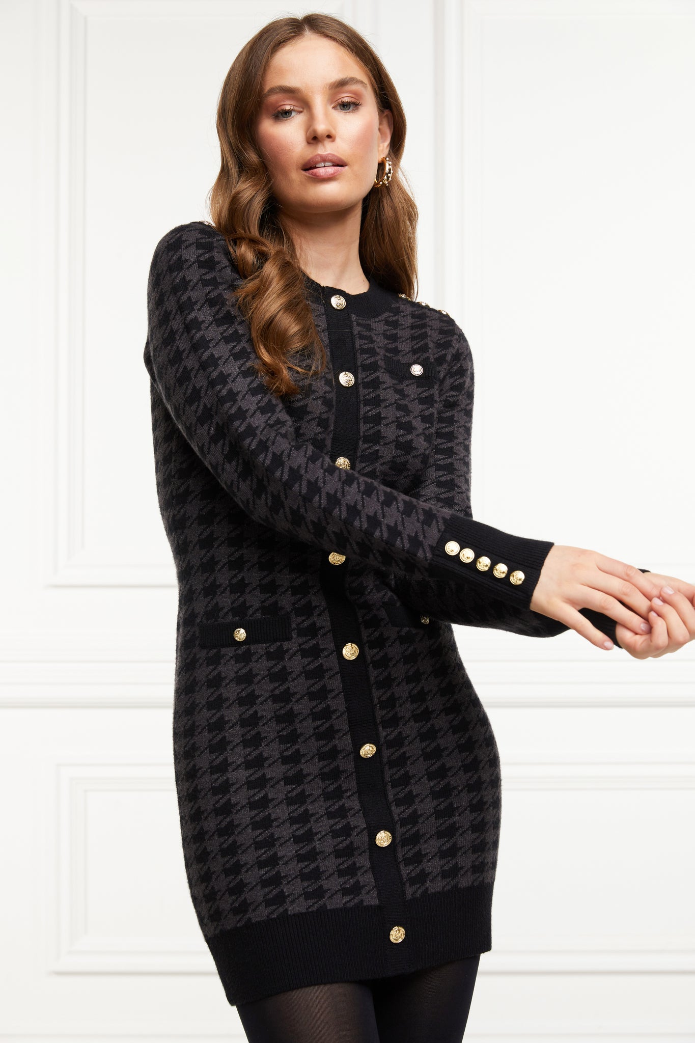 womens slim fit crew neck long sleeve knitted dress in grey and black houndstooth with gold button detail on contrast black panel down the centre front and two black contrast welt pockets on chest and two on the hips with gold buttons on the centre of each and contrasting black ribbed hem neckline and cuffs