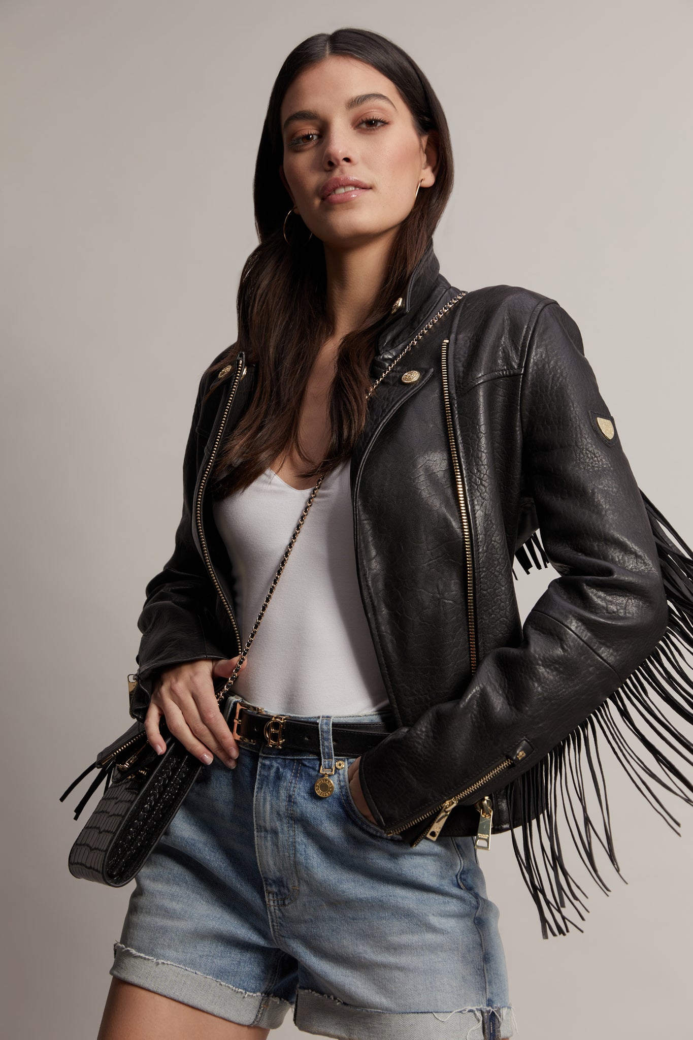 womens leather biker jacket in black with fringing along the back and sleeves detailed with golf zips and small shield badge on arm