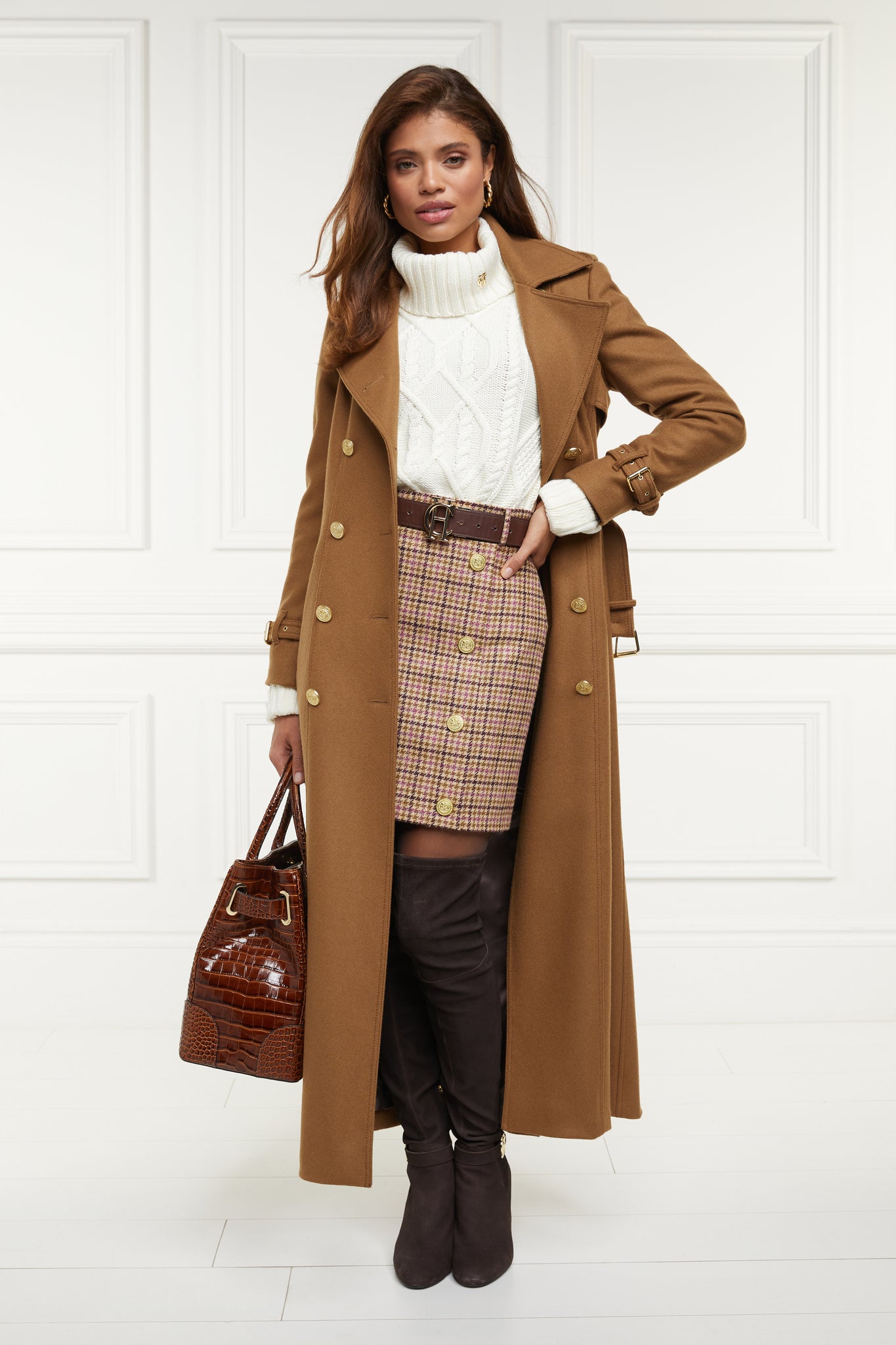 womens wool pencil mini skirt in pink check with concealed zip fastening on centre back and gold rivets down front worn with dark camel full length trench coat