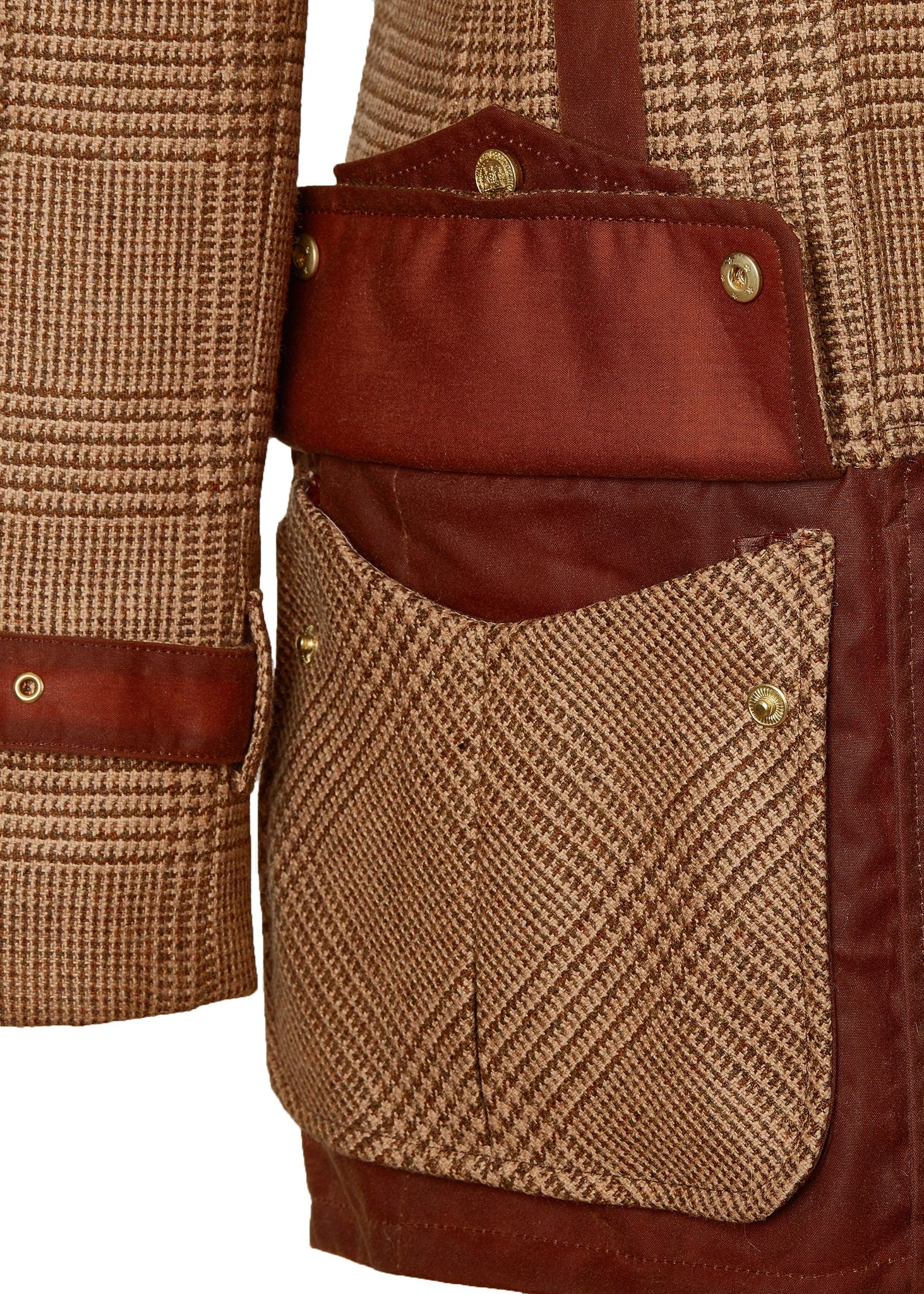 open pocket detail on hip of womens fitted field jacket in tawny and brown check tweed trimmed with contrast tan wax fabric on shoulder across back and on the hip with faux fur trim around the neck finished with horn button fastenings an buckles on the collar cuffs and hip