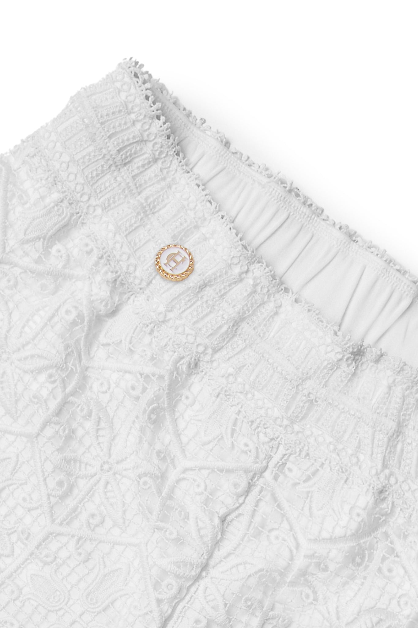 gold and white enamel button detail on womens white floral lace beach short with white opaque underlay and an elasticated waist