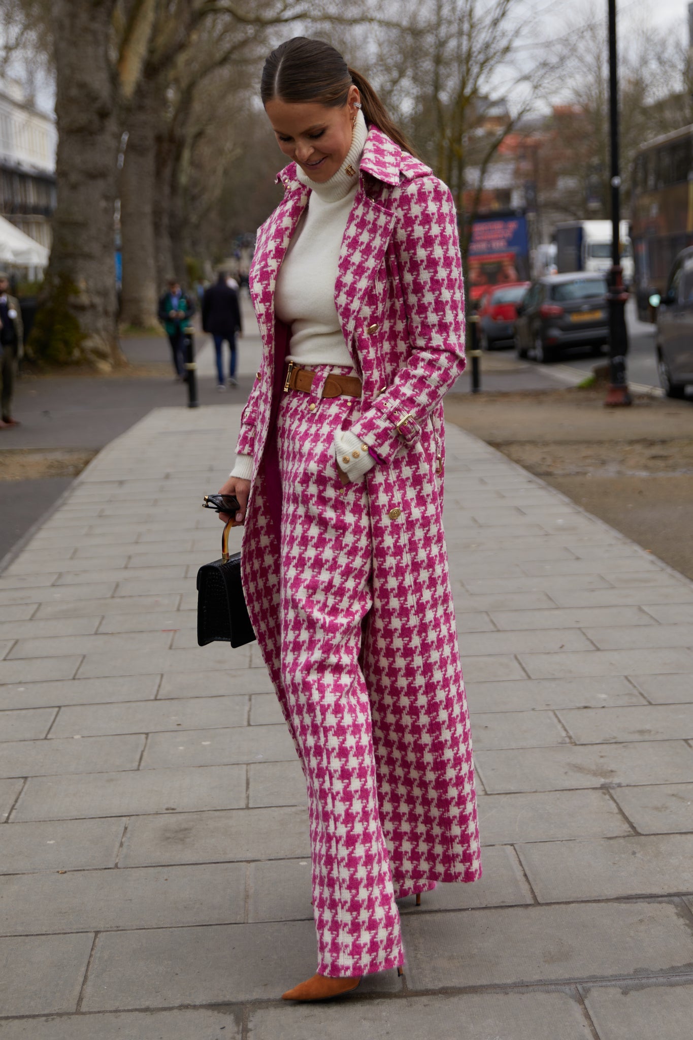 Women's hot pink houndstooth wool high waisted straight trousers with white roll neck top, tan suede belt and hot pink houndstooth trench coat