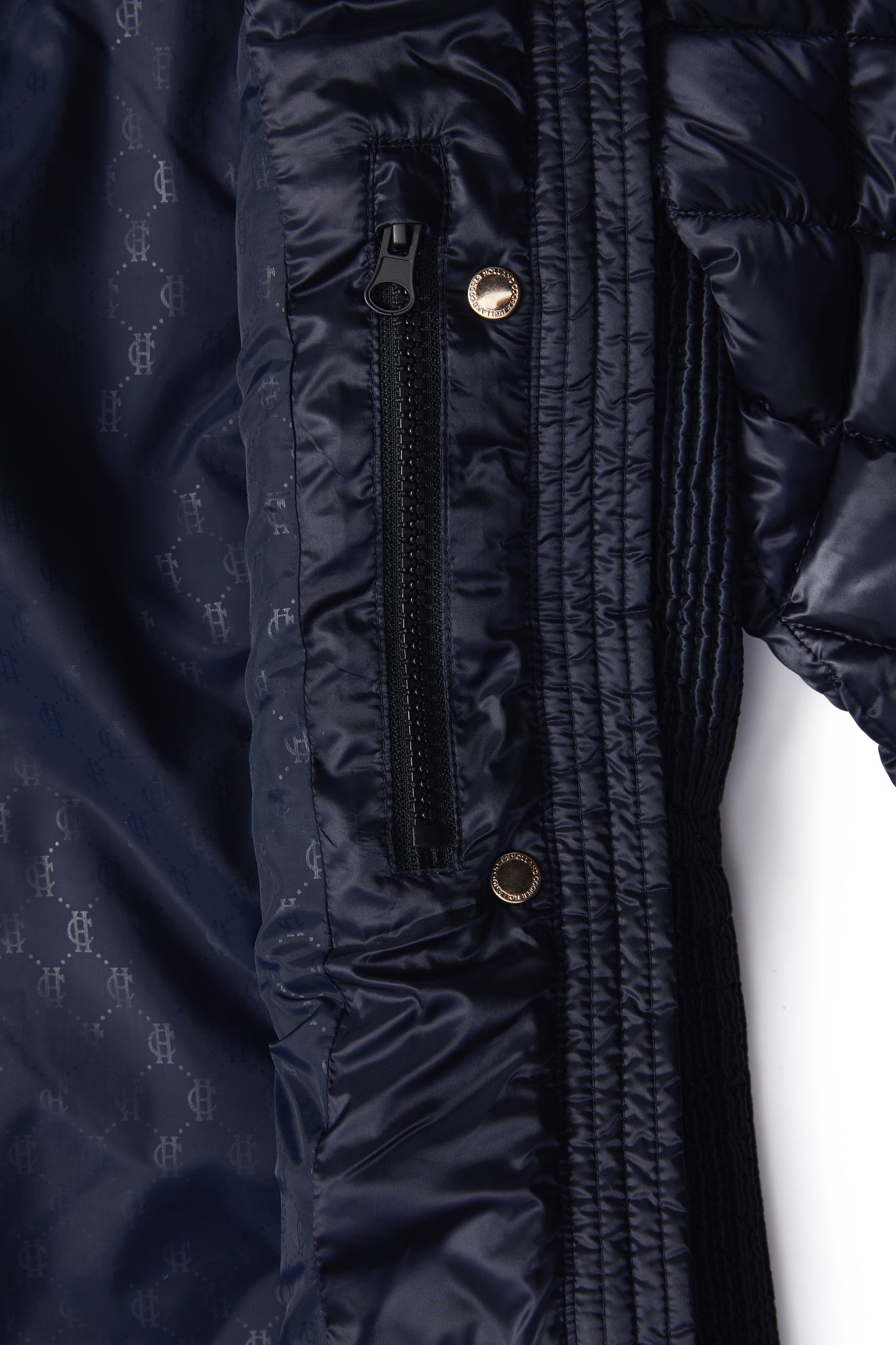 inside pocket detail on womens diamond quilted navy jacket with contrast tan leather elbow and shoulder pads large front pockets and shirred side panels