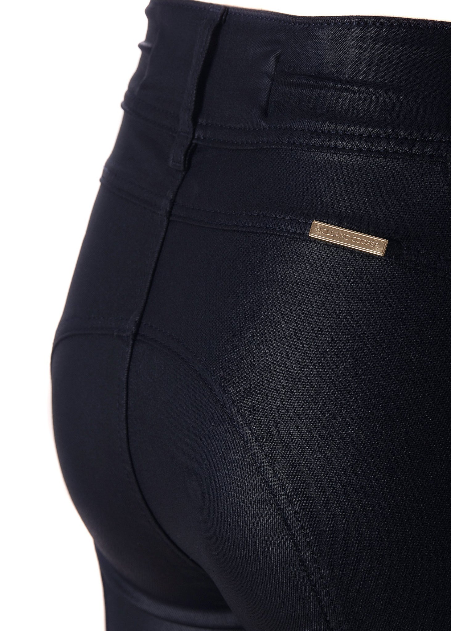 gold hardware detail on back of womens high rise blue coated skinny jean for a waxed look with jodhpur style seams with two open zip pockets to the front with HC branded pulls