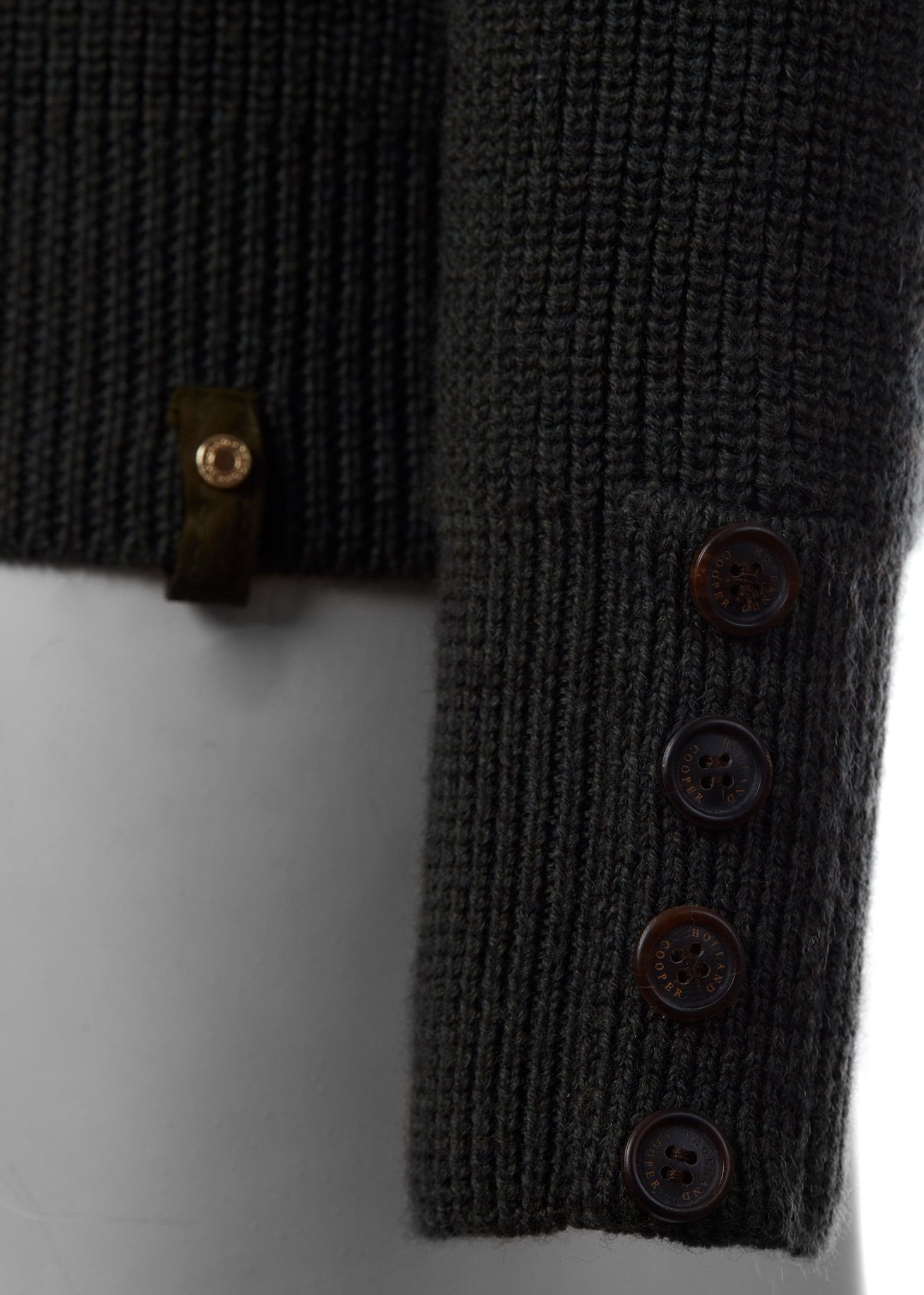 horn button detail on cuffs of classic crew neck slim fit merino wool jumper in forest green with brown faux suede gunpatch on shoulder and quilted elbow patches in the same brown suede material