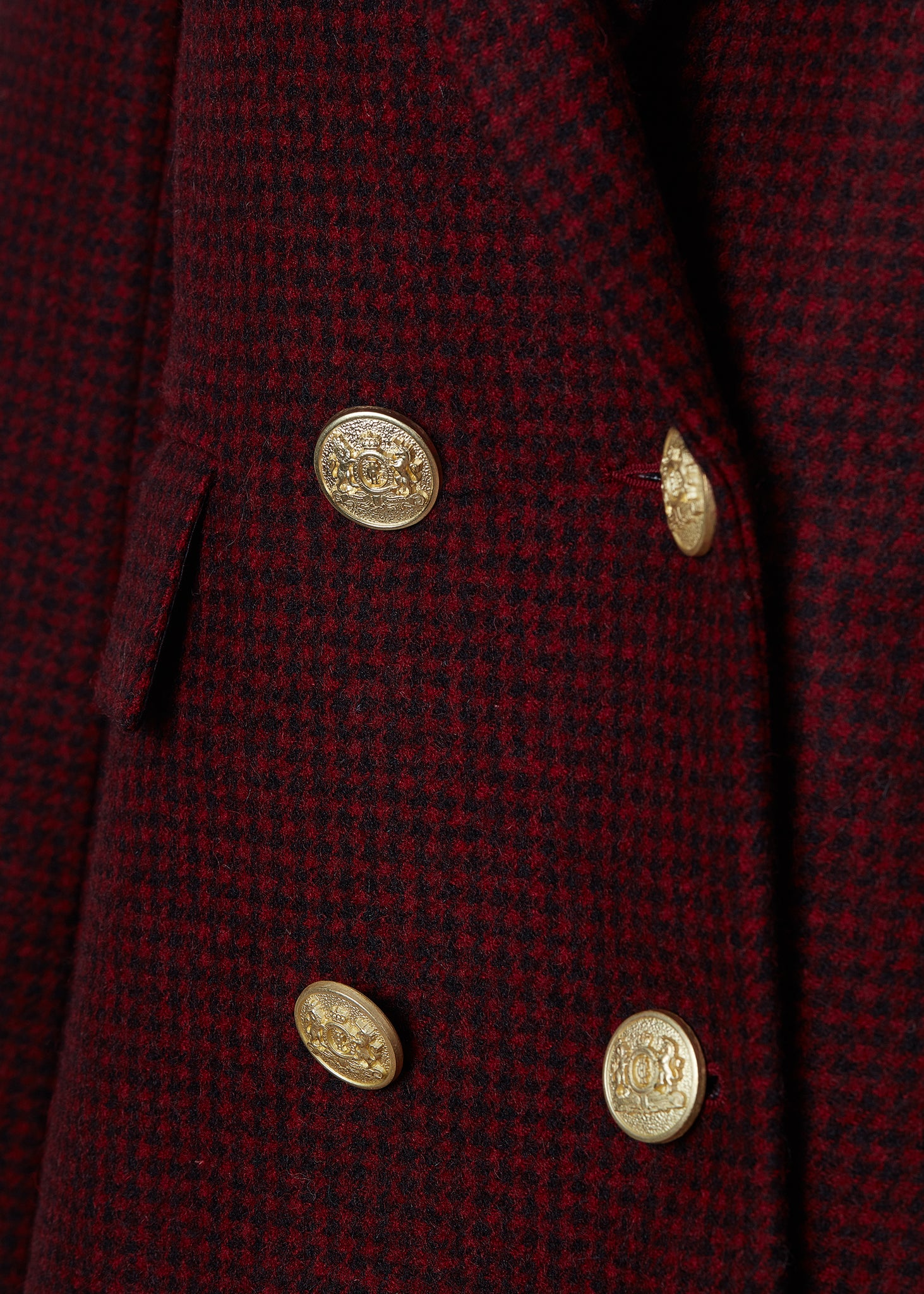 gold button front detail on double breasted wool blazer in deep red houndstooth with two hip pockets and gold button detials down front and on cuffs and handmade in the uk