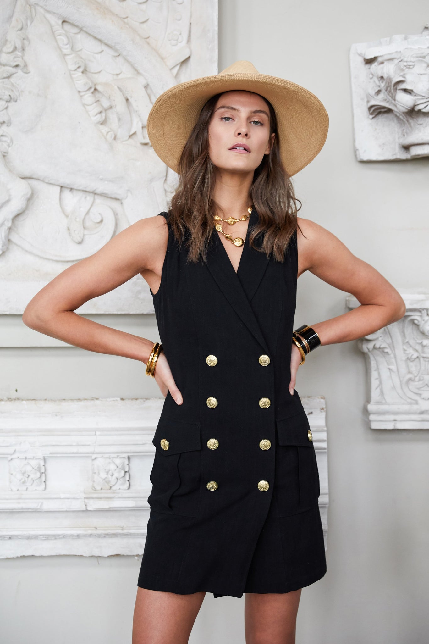 womens black linen sleeveless collared mini dress with gold button front fastening and natural fedora