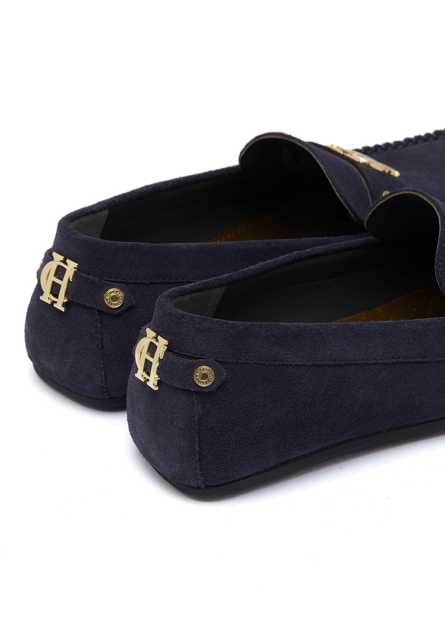 back of navy suede loafers with a leather sole and top stitching details and gold hardware