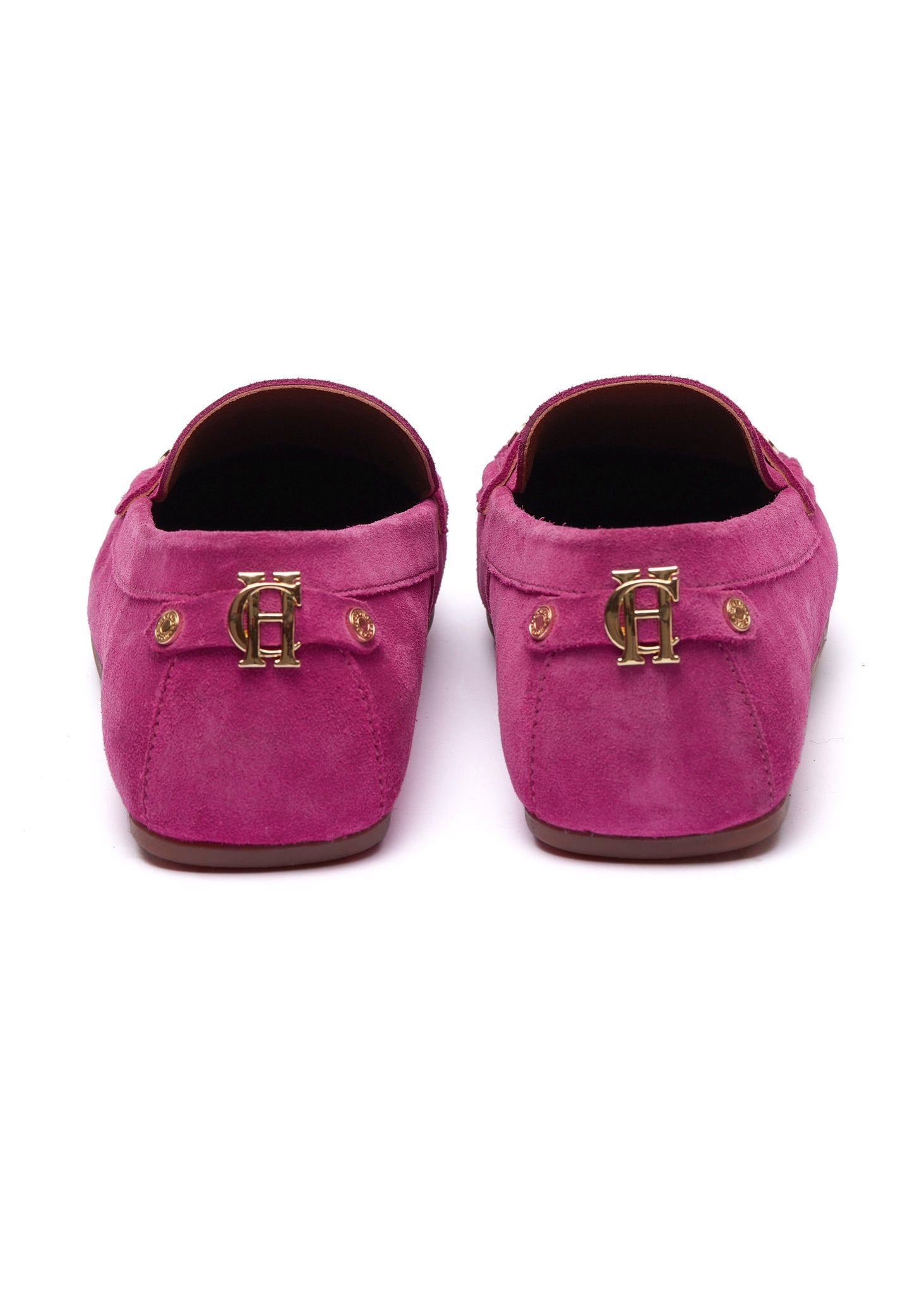 Back of bright pink suede loafers with a leather sole and gold hardware