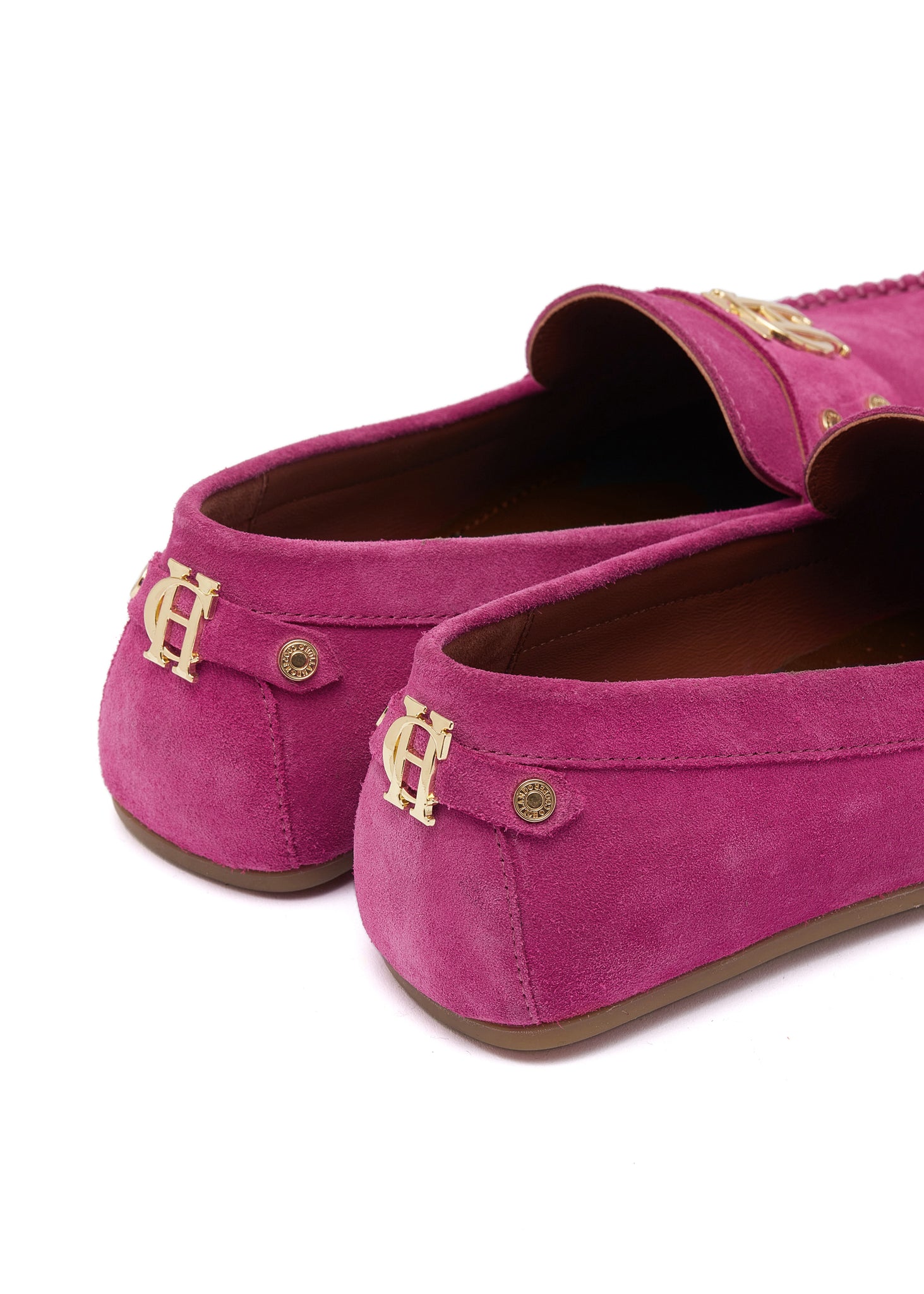back of bright pink suede loafers with a leather sole and top stitching details and gold hardware
