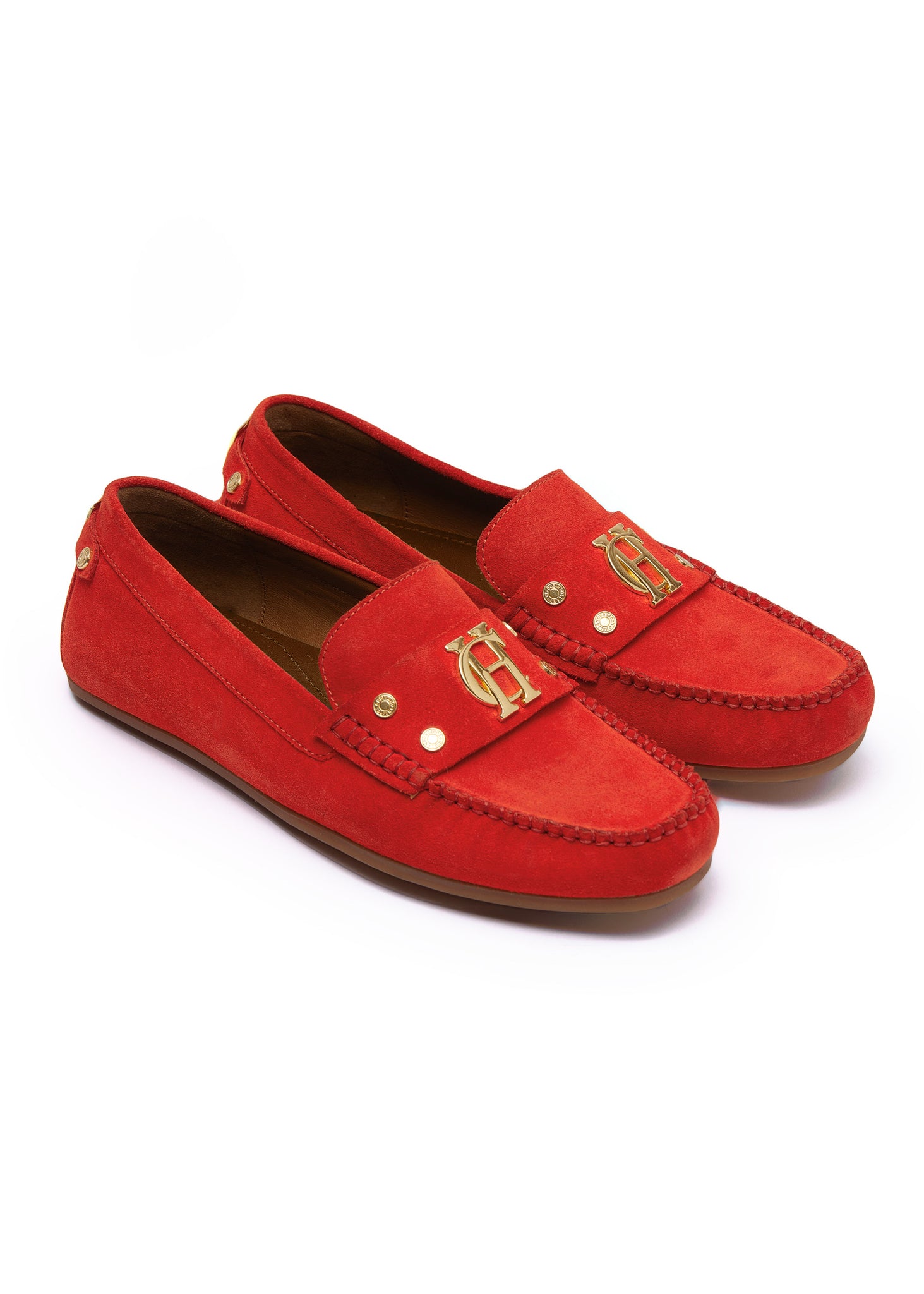 orange suede loafers with a leather sole and top stitching details and gold hardware and tan inner sole