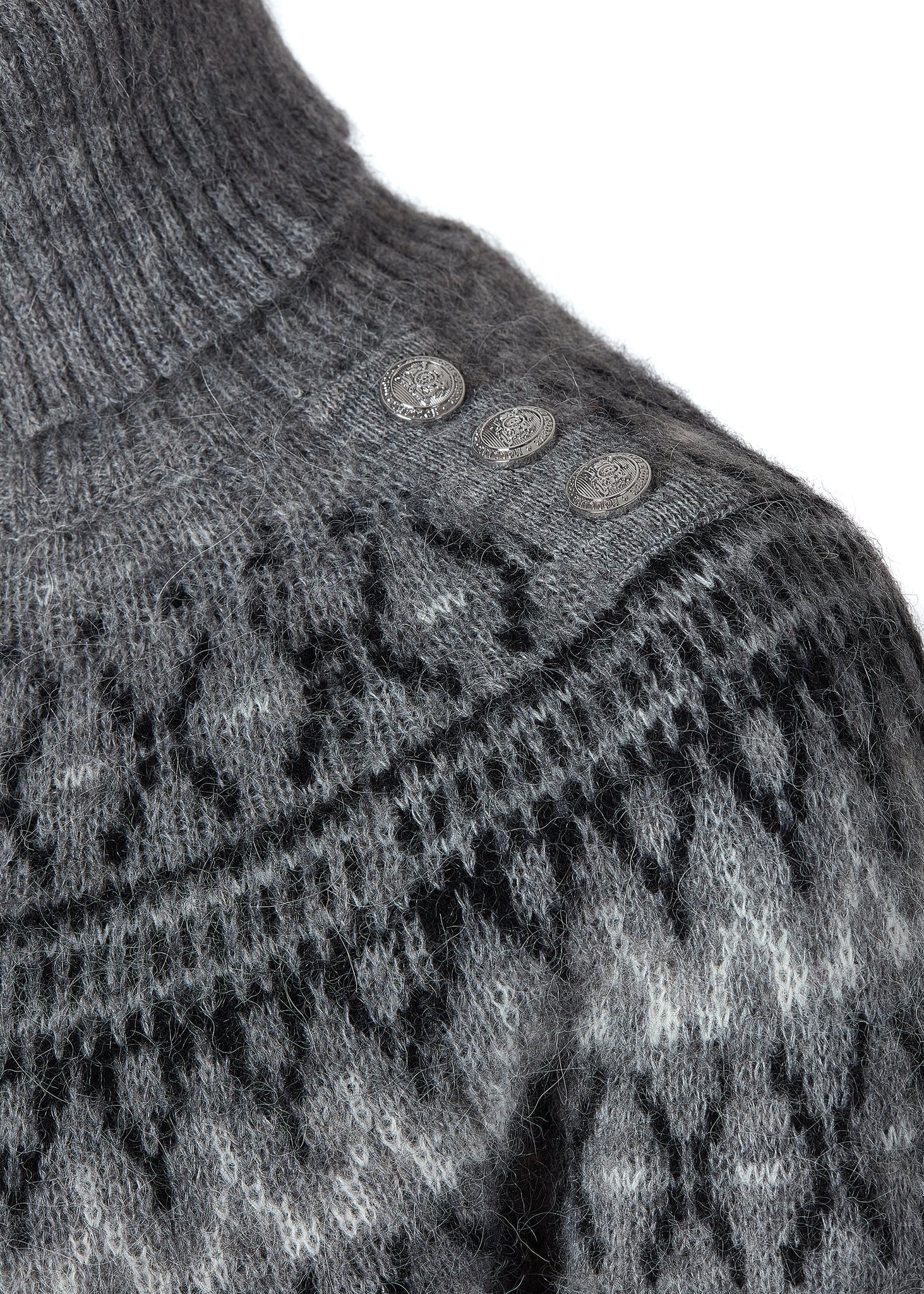 silver button detail on shoulders of womens classic grey roll neck jumper with fairisle knit in black and white around the shoulders waistline and cuffs and a split ribbed hem