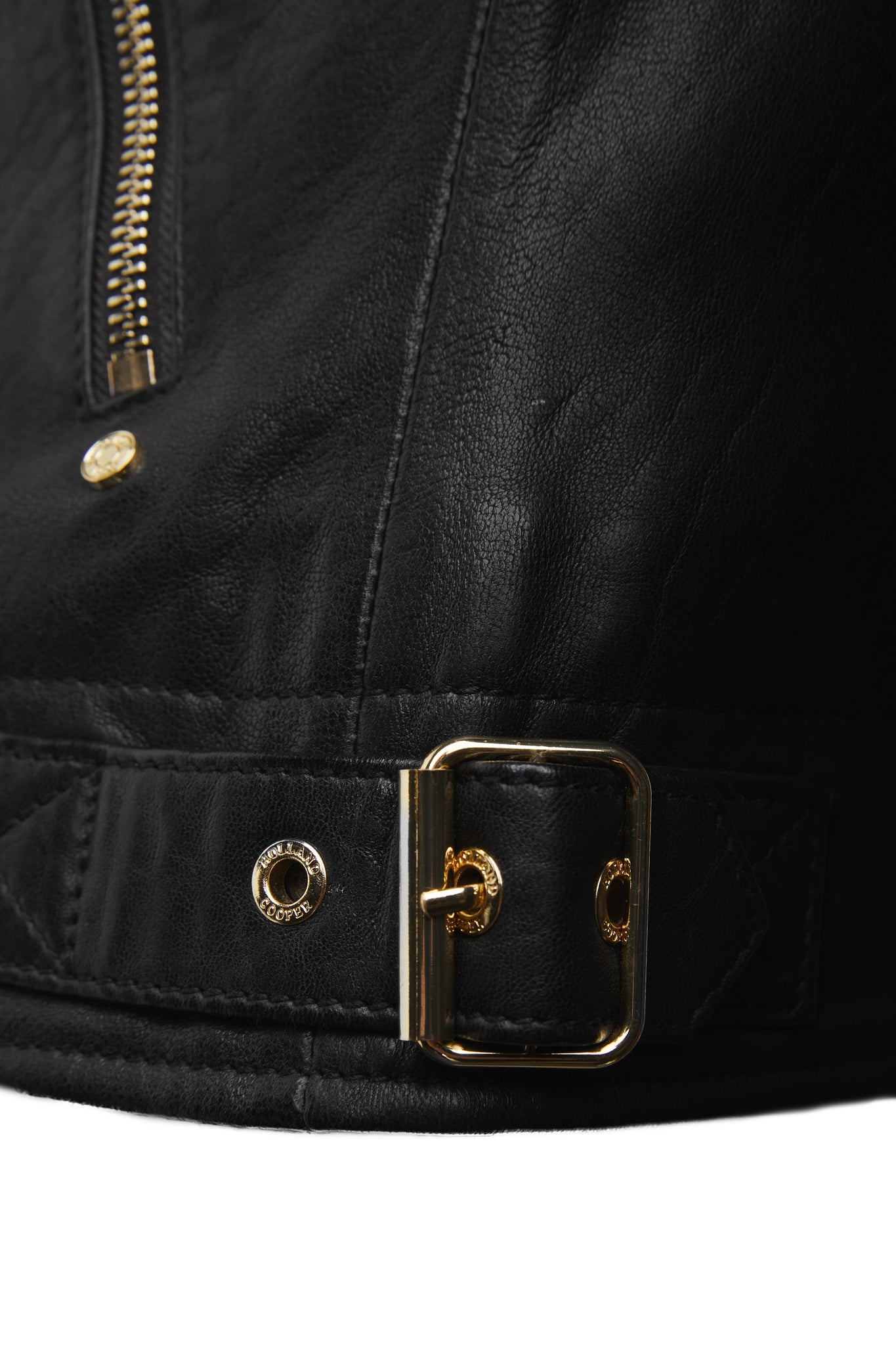 gold buckle detail at hem of womens leather biker jacket in black with fringing along the back and sleeves detailed with golf zips and small shield badge on arm
