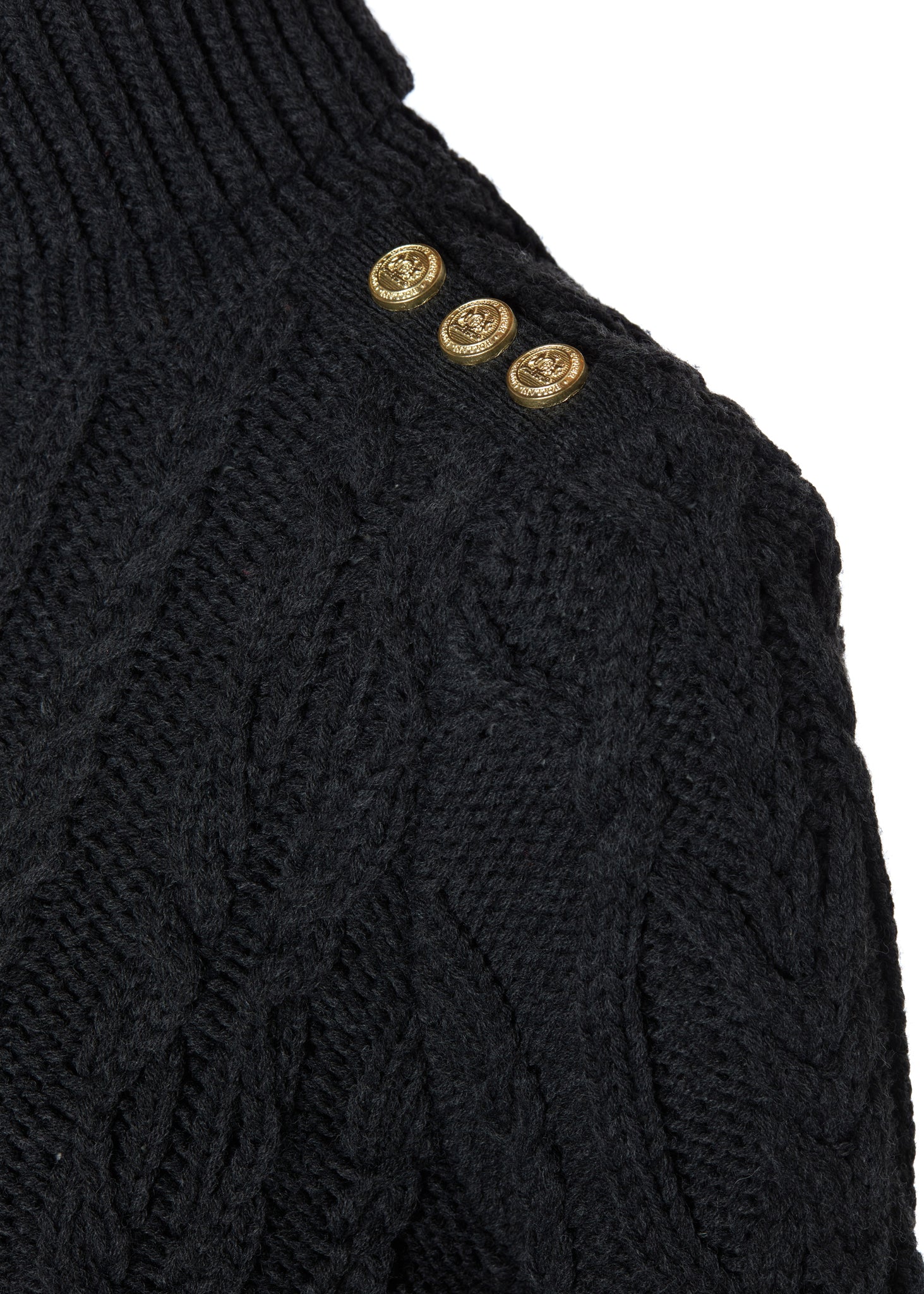 gold button detail across shoulders of a chunky cable knit roll neck jumper in dark grey with dropped shoulders and thick ribbed cable trims and gold buttons on cuffs and collar