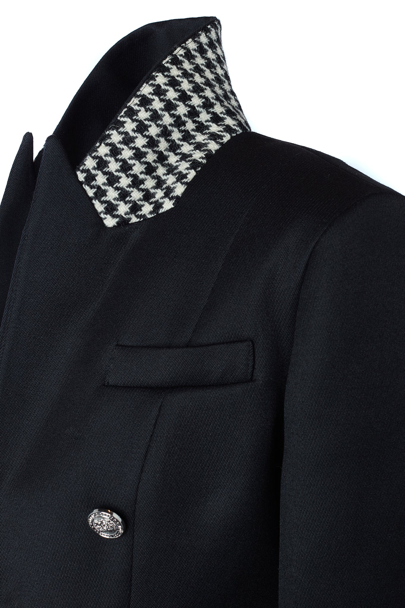 detail of houndstooth under collar on British made tailored cropped jacket in black with welt pockets and gold button detail down the front and on sleeves