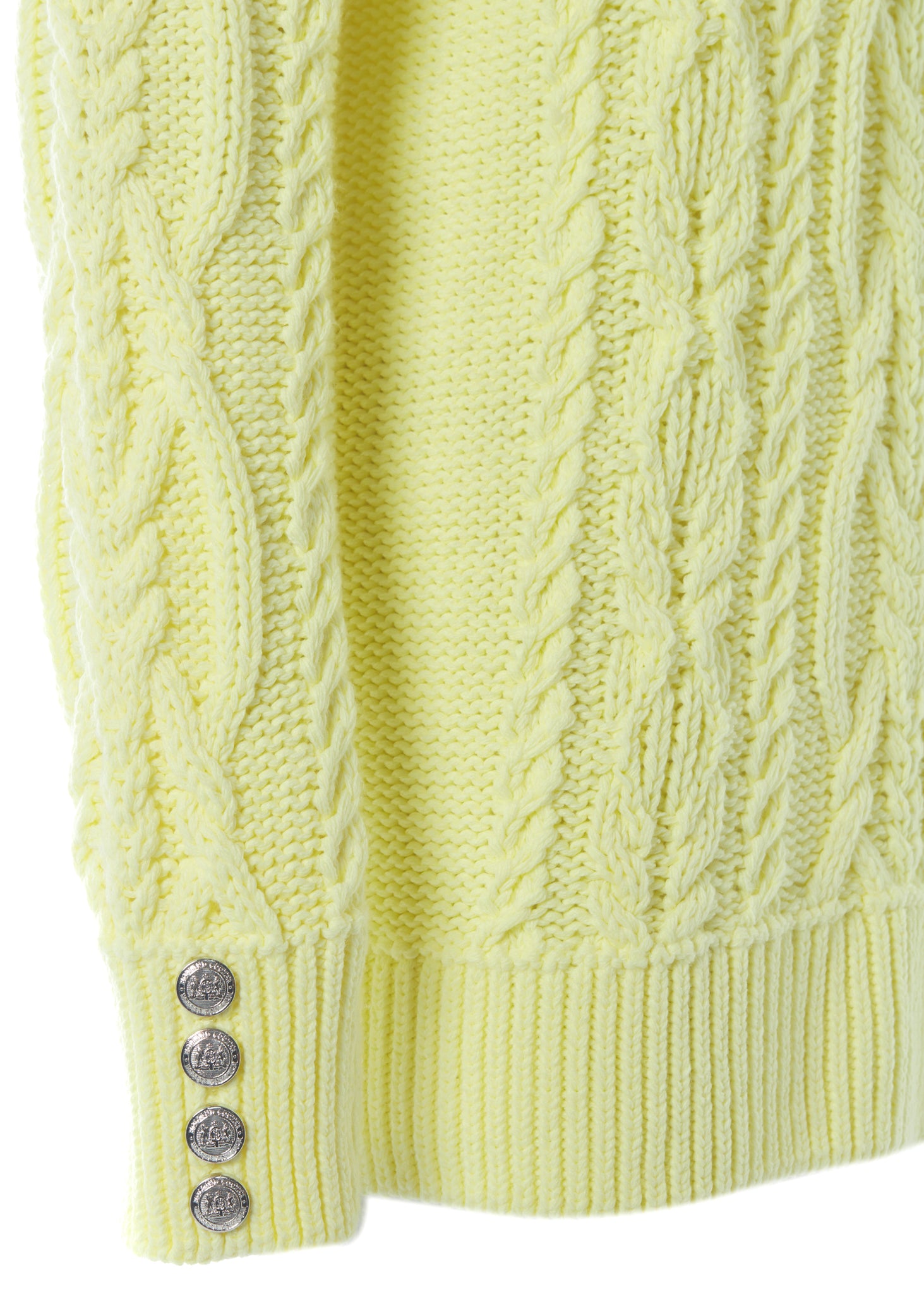 silver button detail on cuffs of chunky cable knit jumper in lemon yellow with ribbed roll neck hem and cuffs
