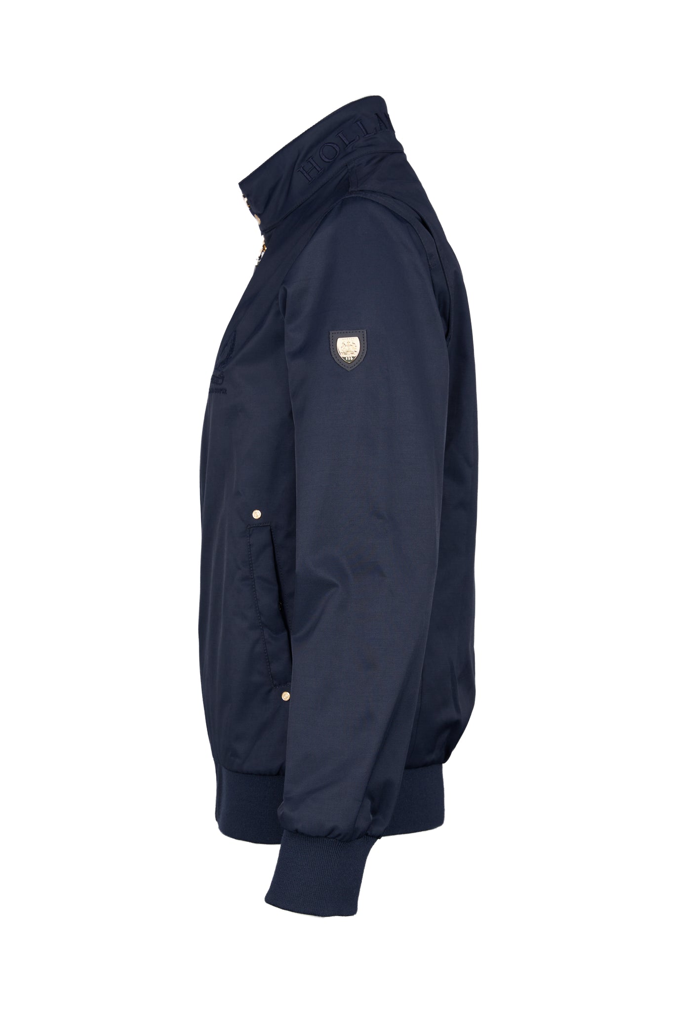 side of Womens navy 100% waterproof hoodless bomber style jacket with ribbed cuffs and hem, two pockets on hips a full zip down the centre front showing shield badge detail to the upper arm side pockets and navy embroidery to the collar 