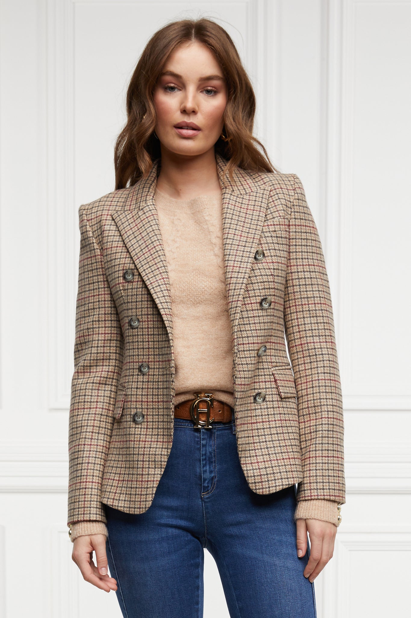 British made double breasted blazer that fastens with a single button hole to create a more form fitting silhouette with two pockets and horn button detailing this blazer is made from camel coloured charlton tweed worn with camel crew neck blazer and indigo jeans 