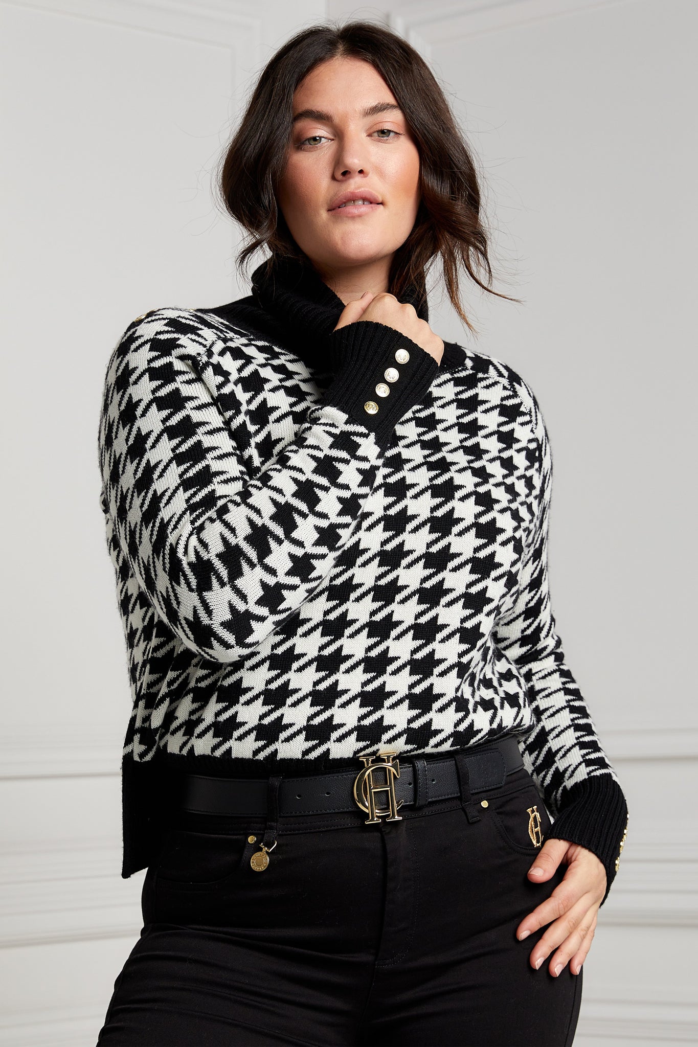 a classic black and white houndstooth jumper with contrast black cuffs, roll neck and split ribbed hem with gold button detail on the cuffs and collar