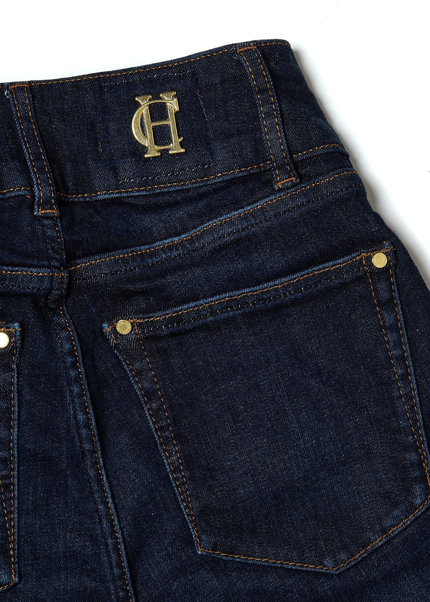 back pocket detail on womens high rise dark blue denim flared jean with centre front zip fly fastening with two open pockets at the front and back with gold hardware on back waistband 