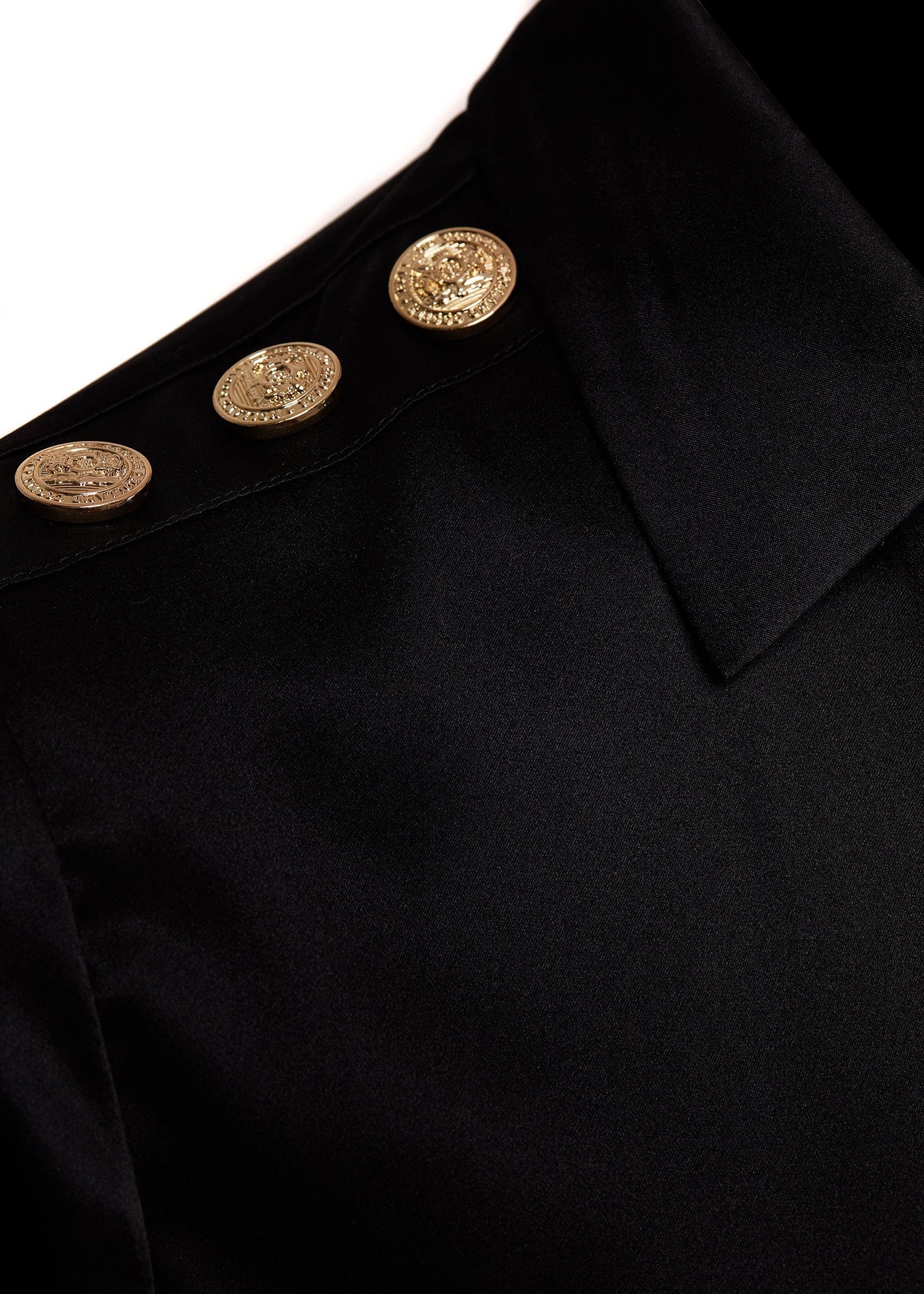 gold button shoulder detail of womens long sleeve black silk v neck blouse with gold buttons