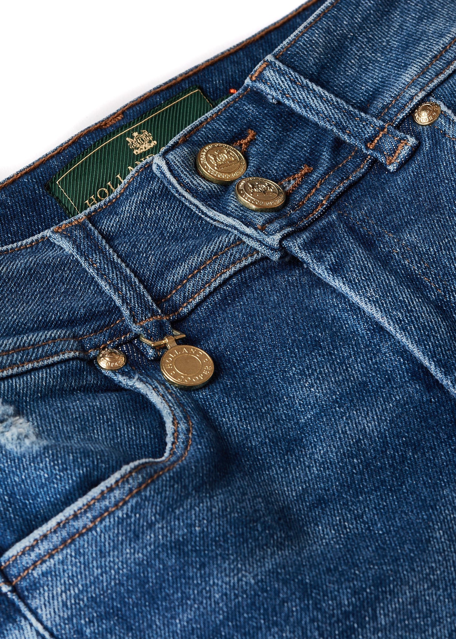 gold charm on belt loop detail on womens high rise blue distressed denim skinny stretch jean with jodhpur style seams and two open pockets to the front with hc embroidery on front left pocket