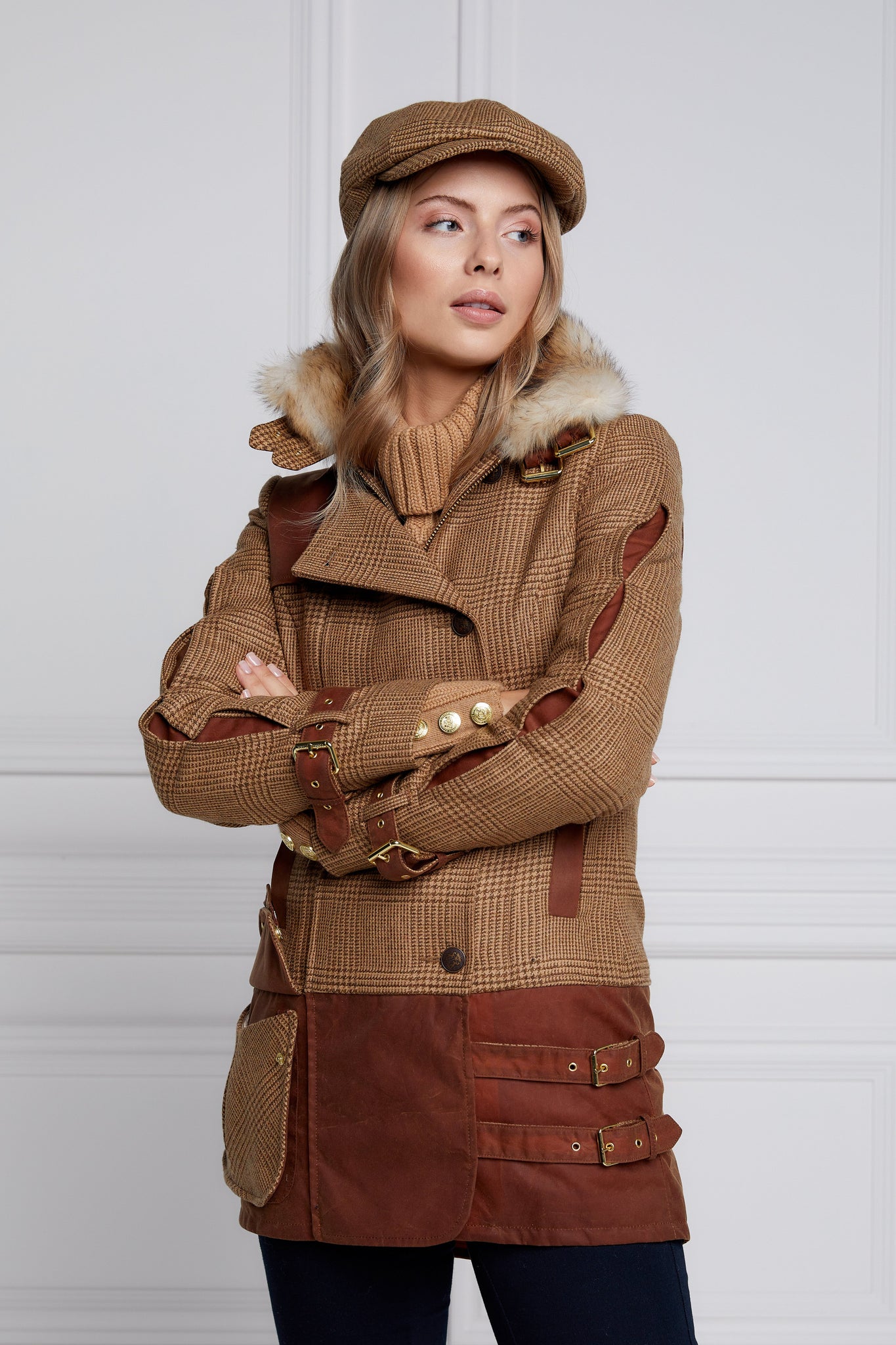 back of womens fitted field jacket in tawny and brown check tweed trimmed with contrast tan wax fabric on shoulder across back and on the hip with faux fur trim around the neck finished with horn button fastenings an buckles on the collar cuffs and hip